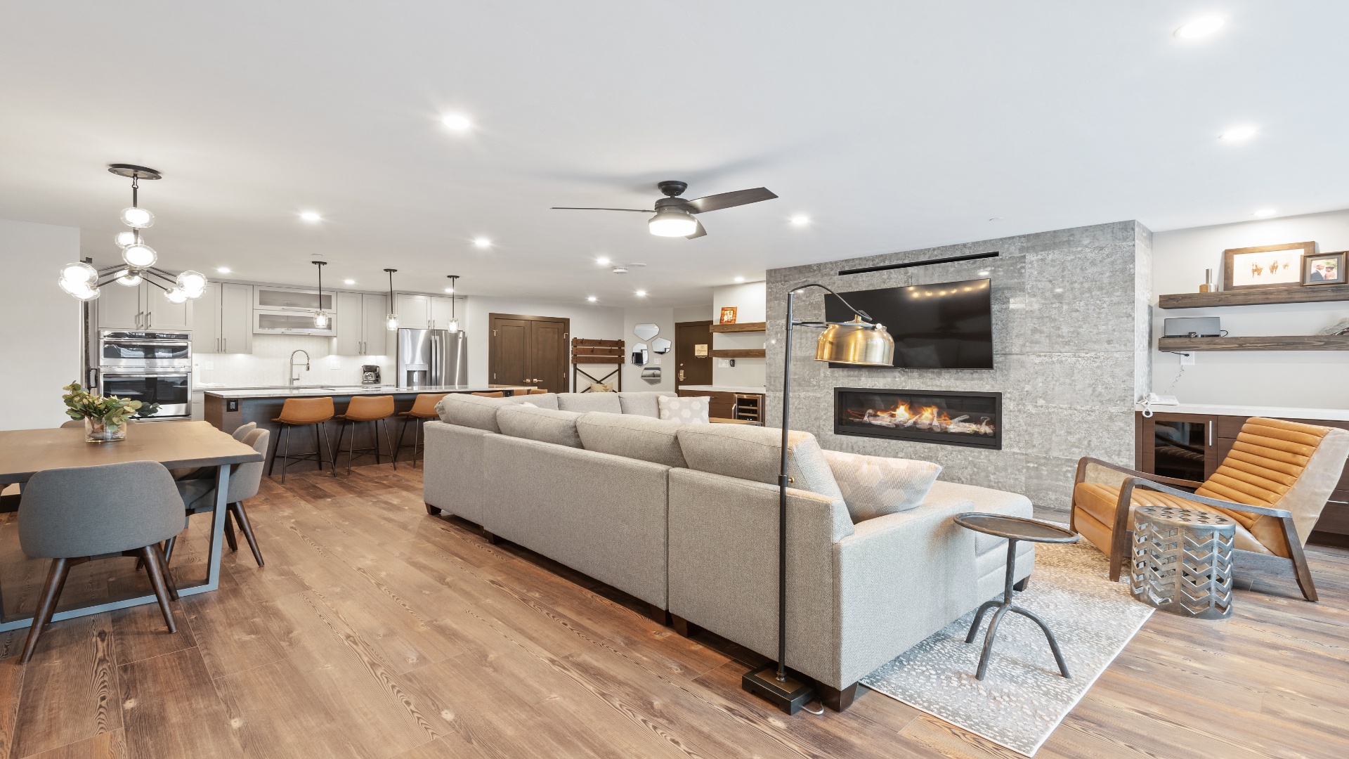 You'll love gathering in this stunning open-concept space, where modern comfort meets thoughtful design. Rich hardwood floors flow seamlessly beneath soaring ceilings, while the fireplace creates a cozy ambiance for memorable evenings together.
