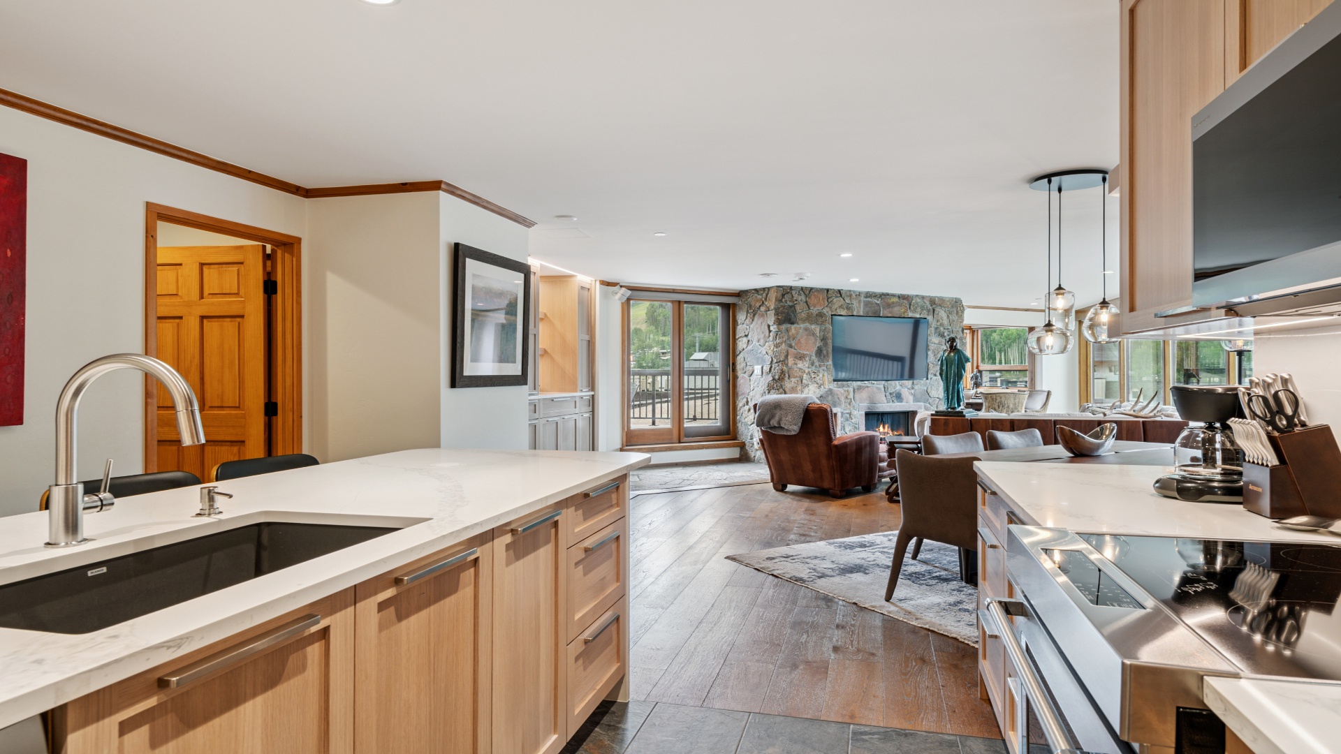 Relax in your spacious open-plan living area where natural light floods through glass doors, a cozy fireplace warms the space, and a modern kitchen awaits your culinary adventures.