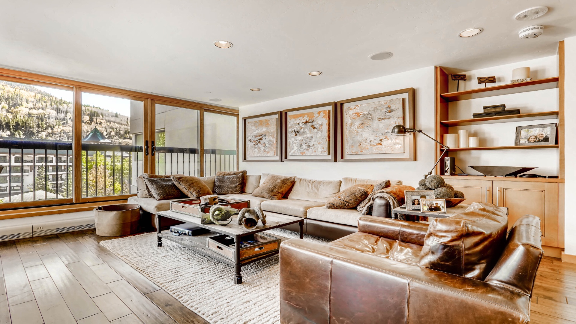 Relax in this inviting living space with plush seating, mountain views through expansive windows, and thoughtful décor that blends warmth with alpine charm.