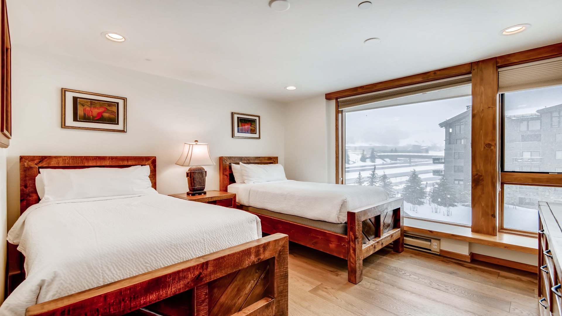 Wake up to a serene winter wonderland framed by your bedroom windows—crisp mountain air, fresh snow, and cozy wooden furnishings surround your restful retreat.