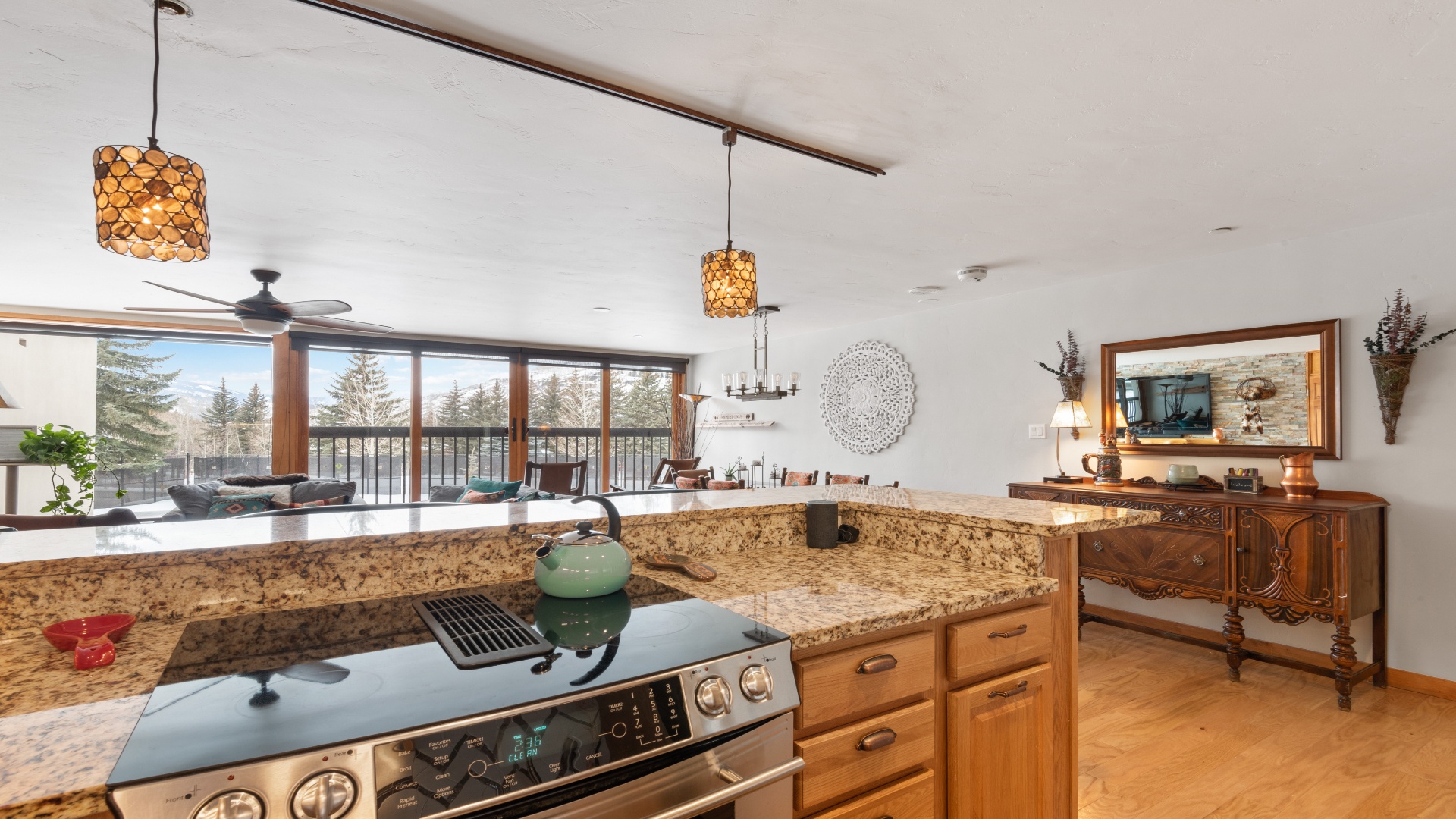 Cook in a sun-filled kitchen with granite counters and watch the trees sway through expansive windows. The open layout lets you chat with guests while you prep meals in this warm, inviting space.