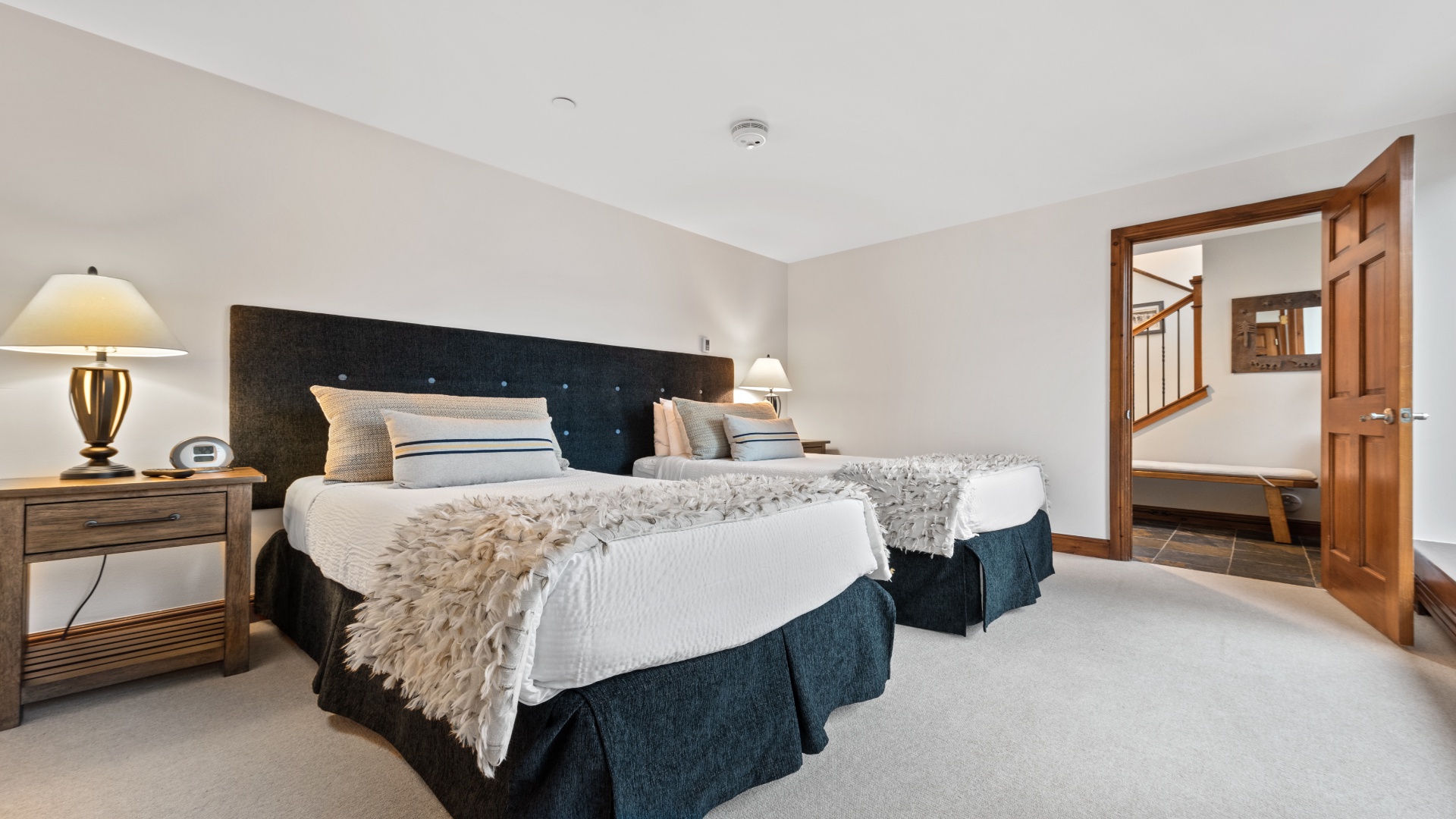 Unwind in your serene bedroom retreat, where a plush bed draped in soft textures invites restful nights, and warm lighting creates a cozy, welcoming ambiance for your stay.
