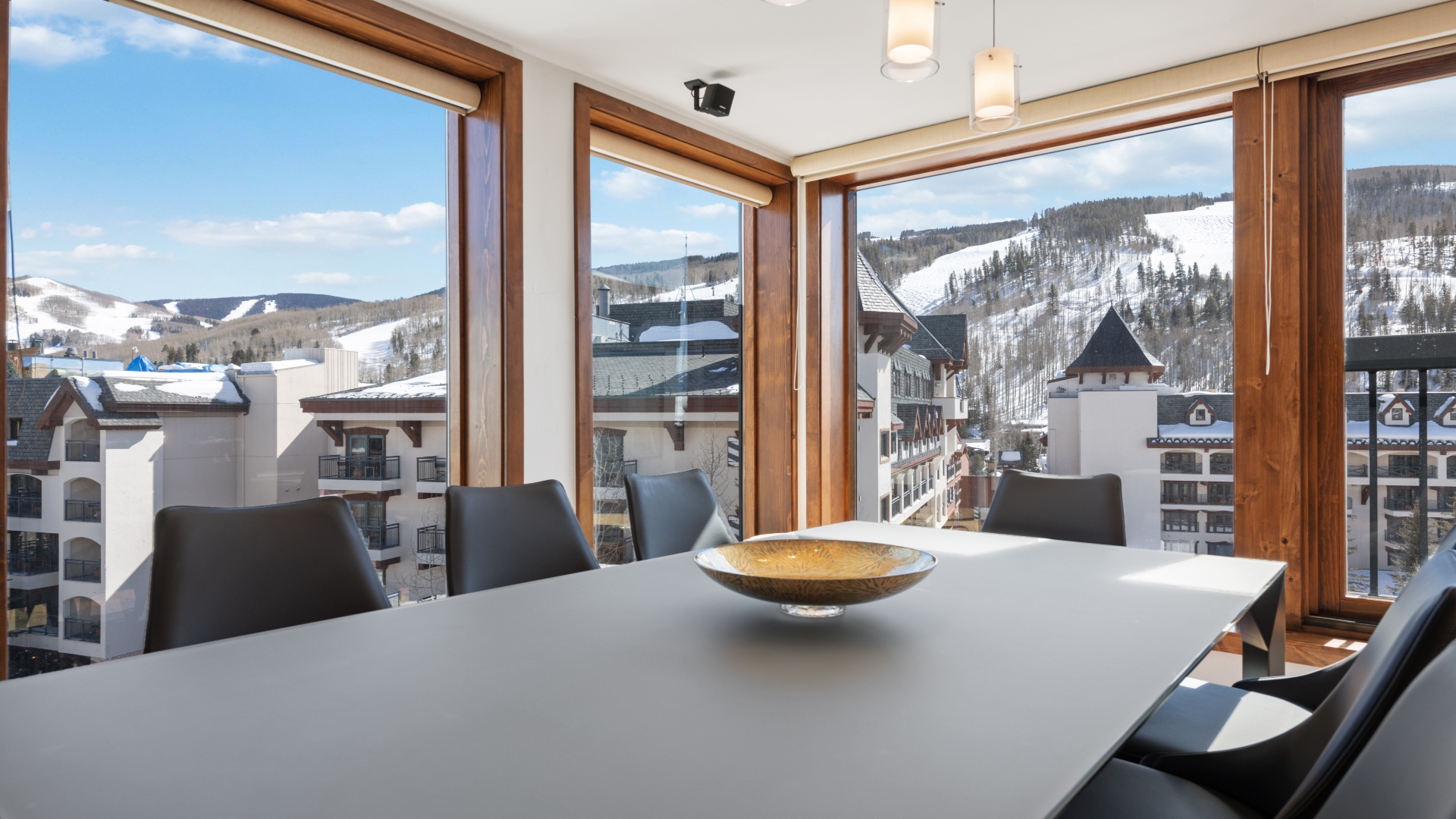 Panoramic alpine views frame your dining space, where floor-to-ceiling windows showcase ski slopes and mountain vistas throughout the day.