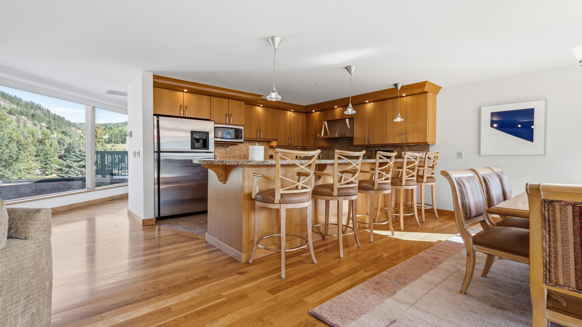 Gather around the breakfast bar in this bright, open kitchen where the mountain views through expansive windows create the perfect backdrop for your morning coffee and shared meals.