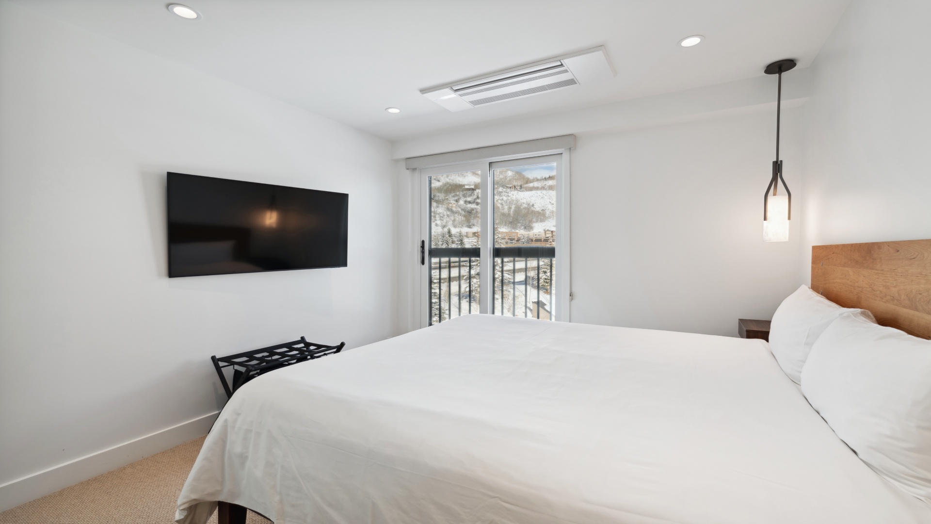 Crisp white linens and modern minimalist design create your peaceful retreat. Wake to mountain views through the balcony doors, unwind with your favorite shows on the wall-mounted TV, and enjoy cool comfort from the ceiling AC.