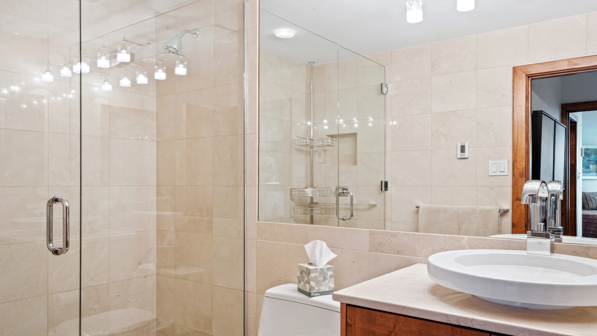 Step into your private spa-like retreat with elegant marble finishes, a spacious walk-in shower, and a sleek vessel sink—everything designed for your comfort and relaxation.