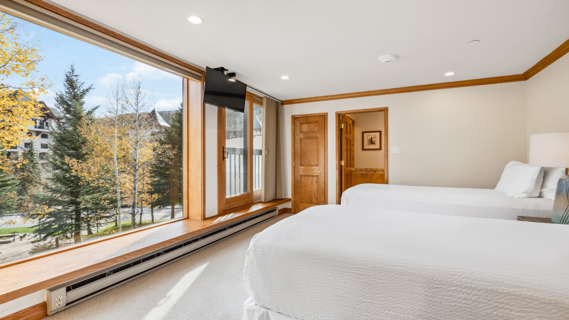 Wake up to stunning autumn views framed by large windows, with soft linens and warm wood accents creating your peaceful mountain retreat.