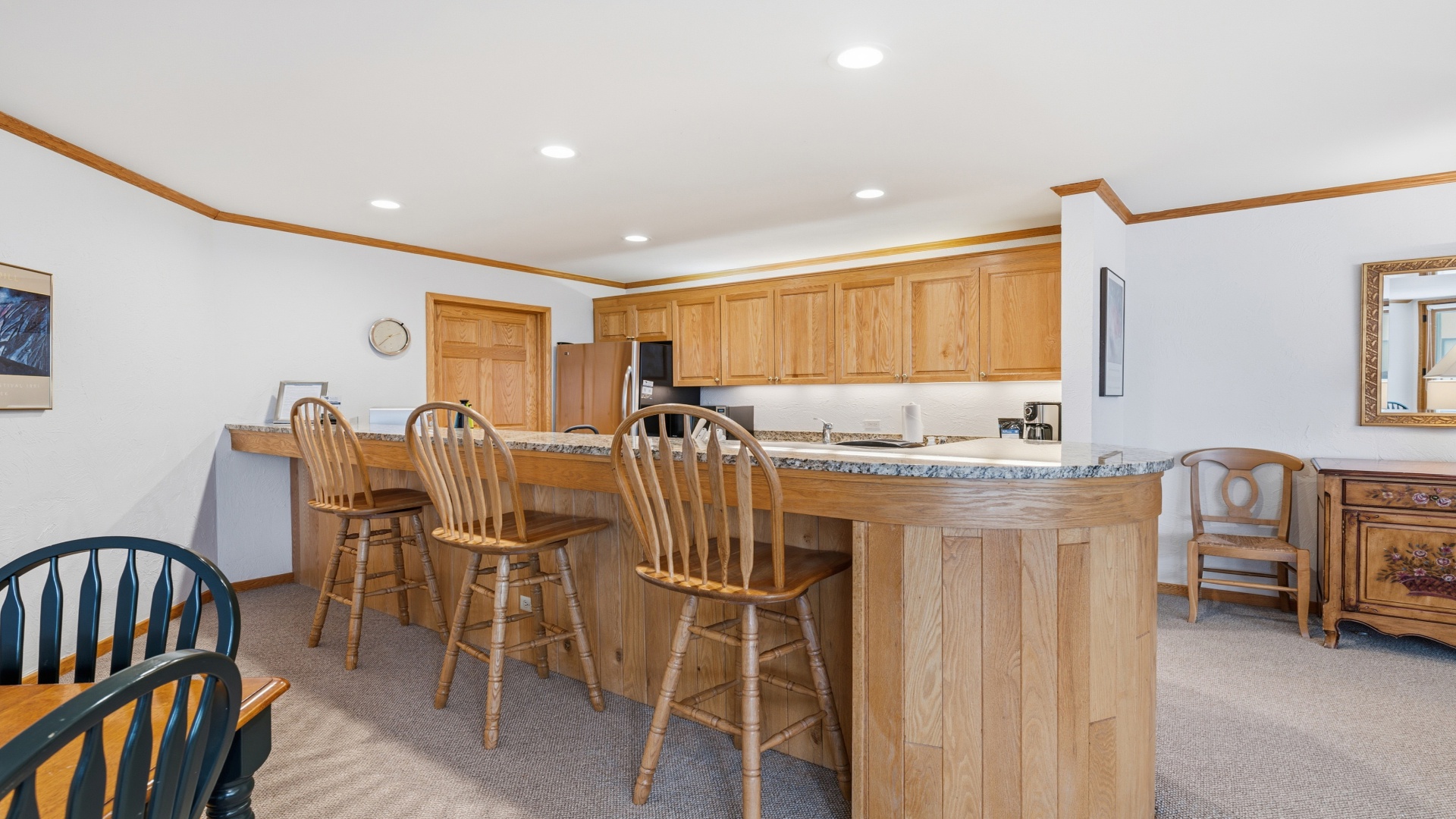 Gather with loved ones at the spacious breakfast bar, where rich wood tones and granite details create a welcoming setting for your morning coffee or casual meals together.