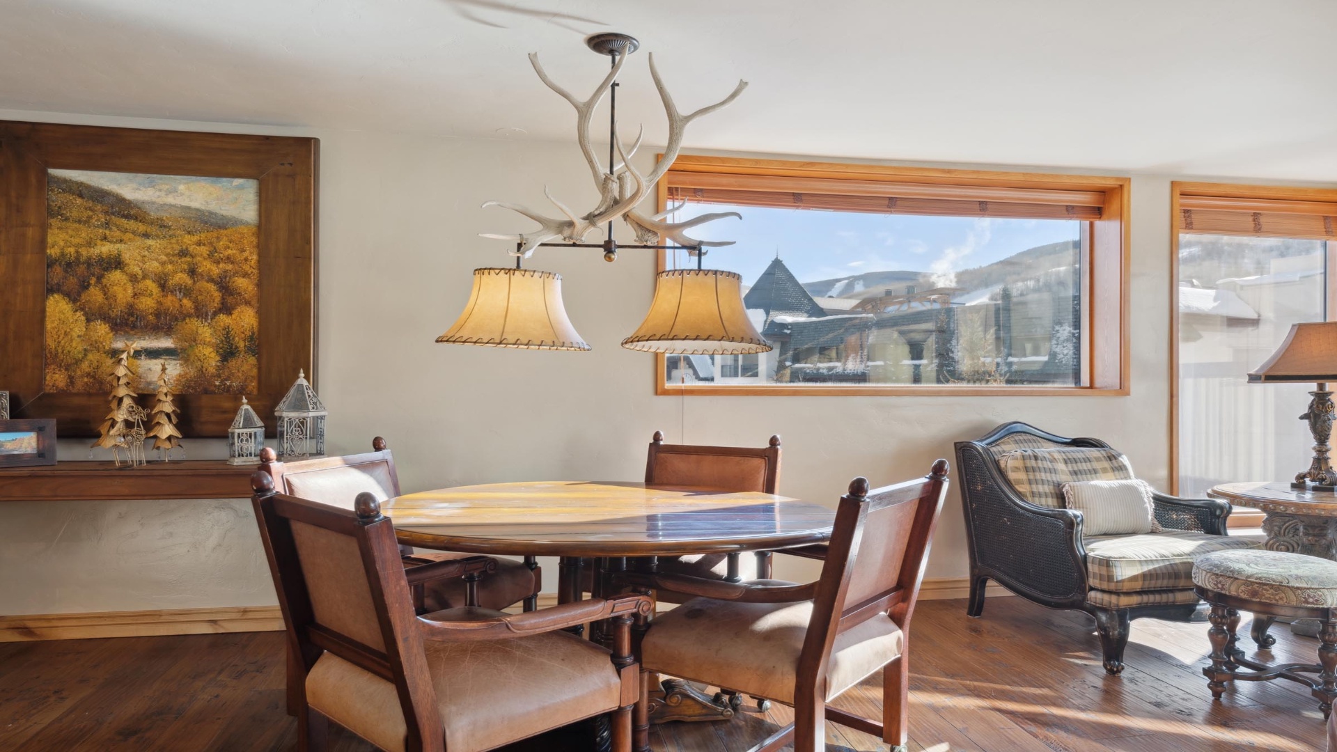 Gather around the dining table for memorable meals, surrounded by rustic mountain charm and stunning views of the surrounding peaks and village through expansive windows.