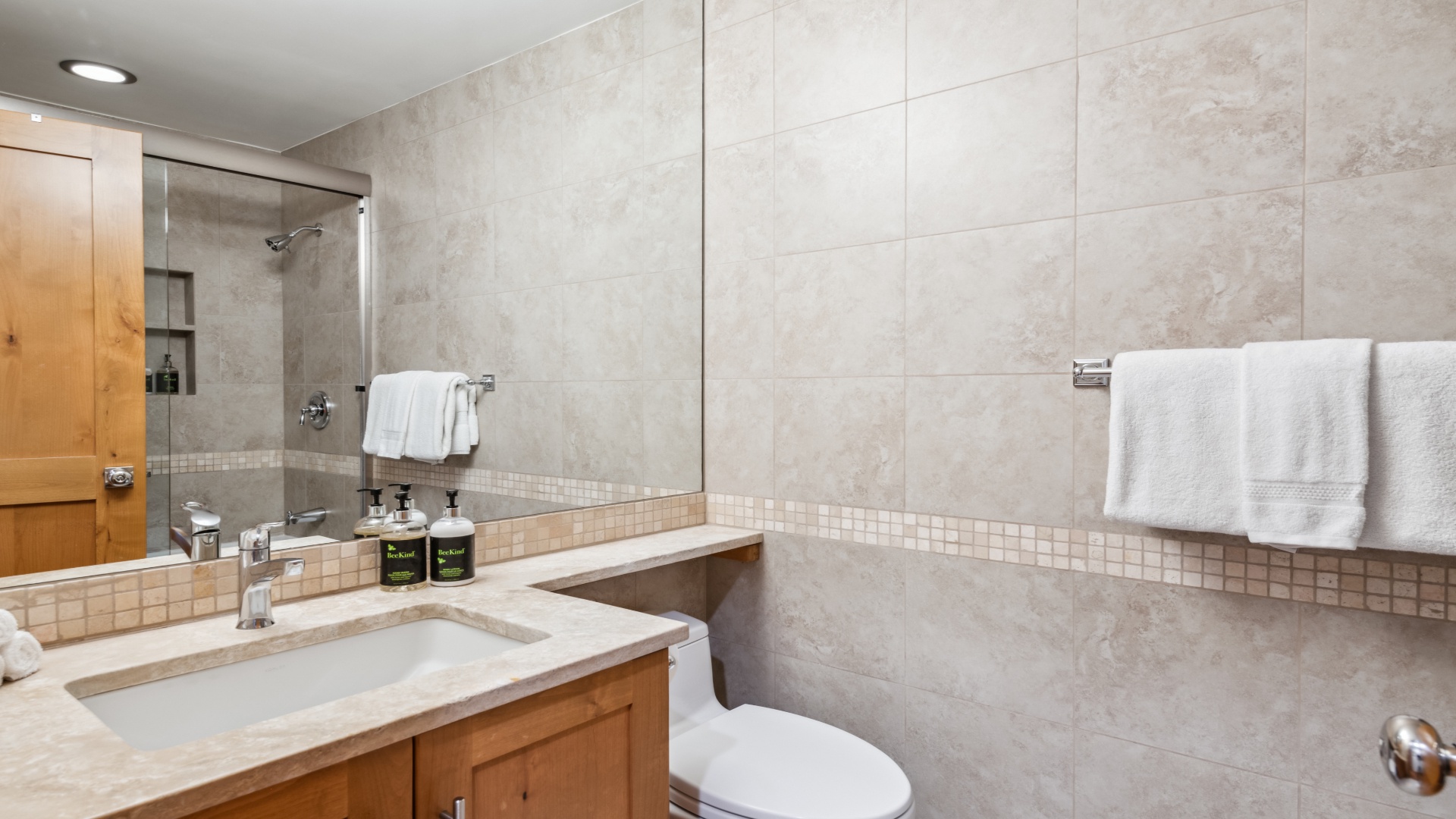 Step into your private spa-like bathroom, featuring modern tile work, a walk-in shower, and plush towels ready for your relaxation.