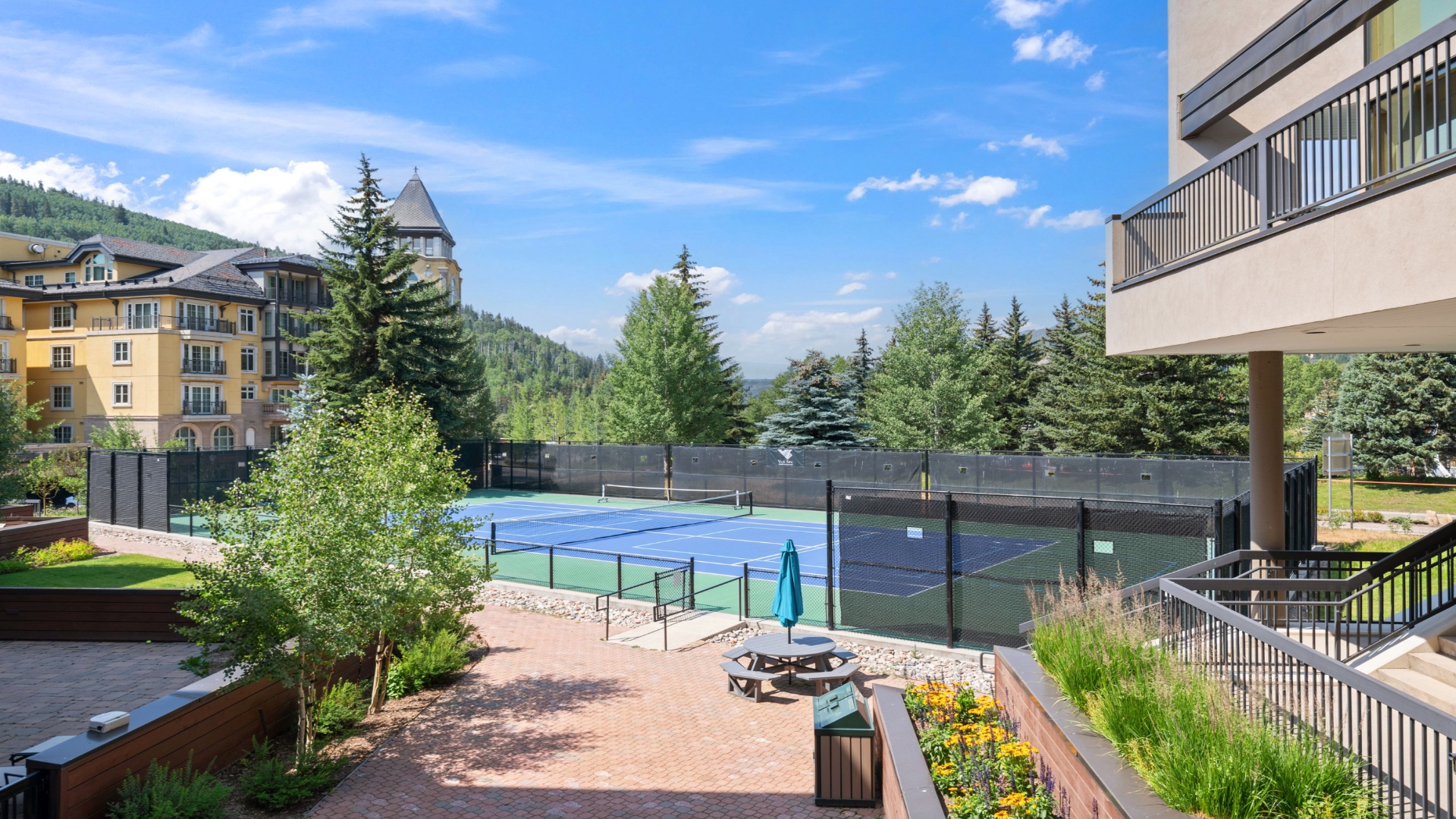 The property features tennis courts set amidst a scenic mountain landscape, offering guests recreational opportunities surrounded by natural beauty and alpine views.