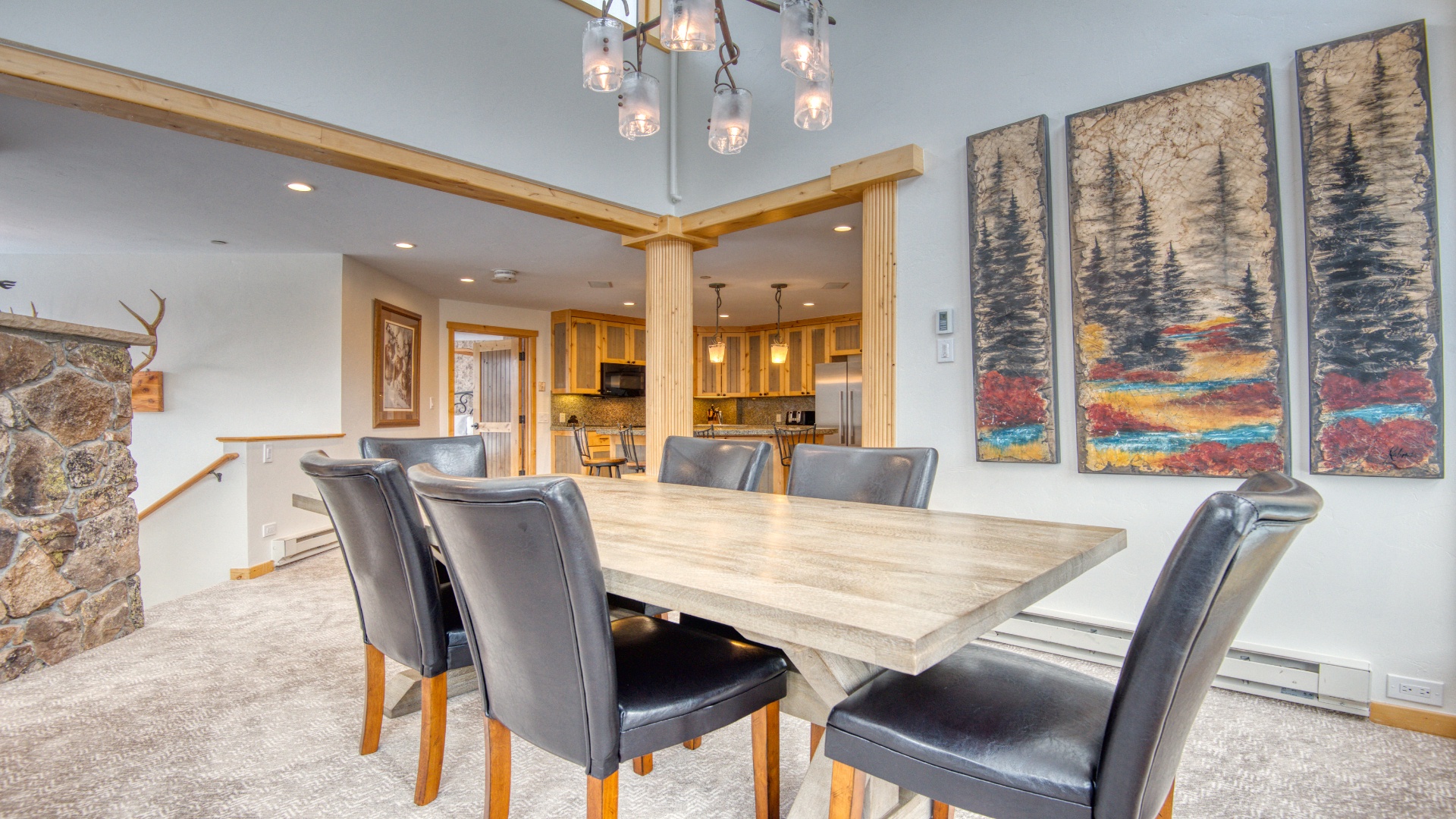 Gather around this spacious dining table with your group, where rustic mountain charm meets modern comfort. The open layout flows seamlessly into your fully-equipped kitchen, perfect for preparing meals together.