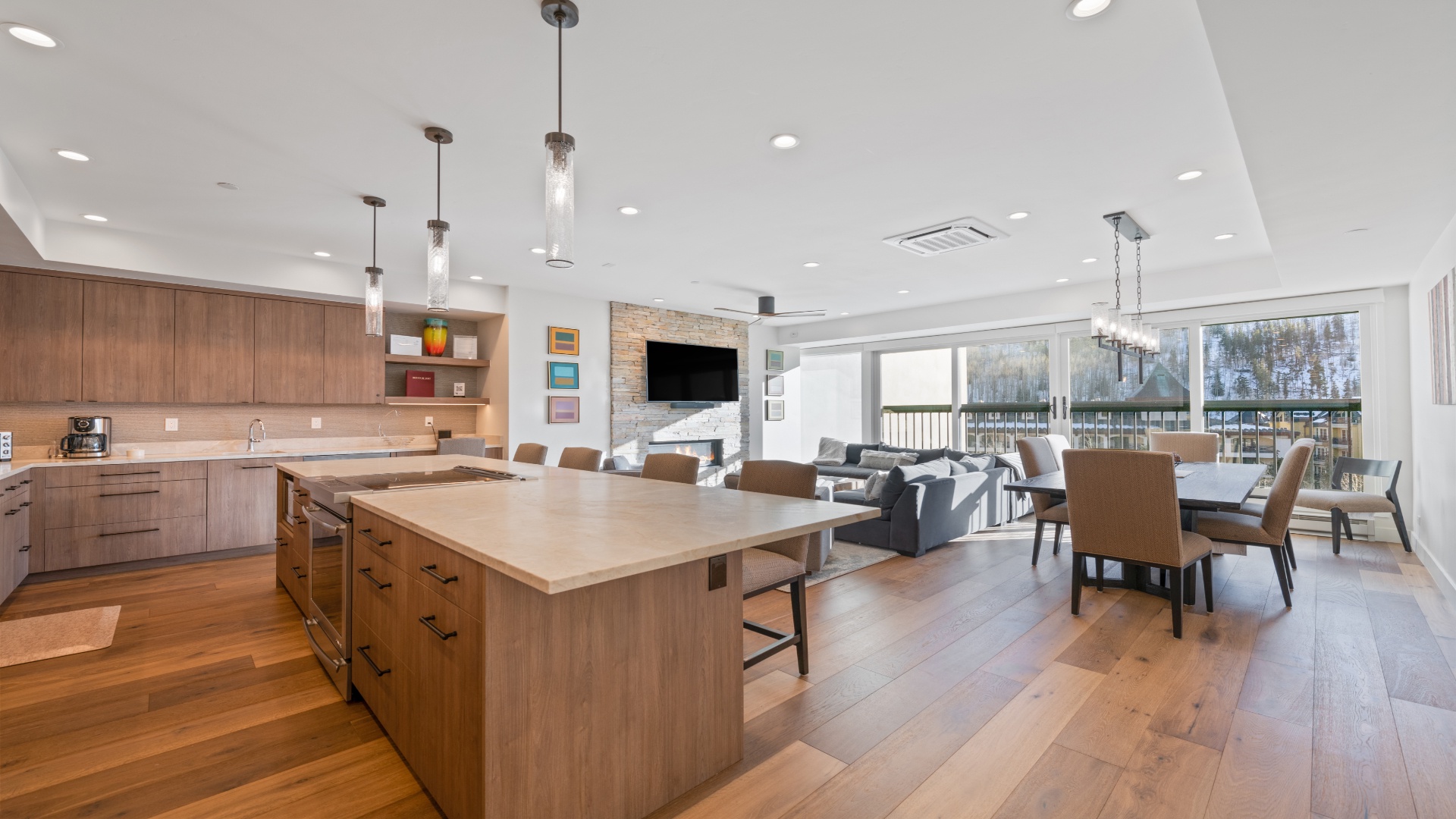 Gather around your spacious open-concept kitchen and living area, where wood tones, modern fixtures, and snowy mountain views create the ultimate retreat for cooking, relaxing, and making memories together.