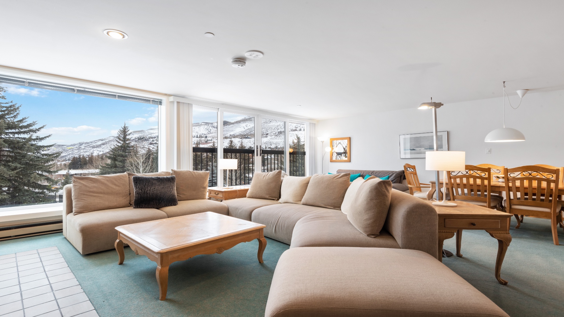 Picture yourself unwinding on this spacious sectional, framed by breathtaking snowy mountain vistas. Natural light floods the open living and dining space, creating a serene alpine retreat perfect for your getaway.