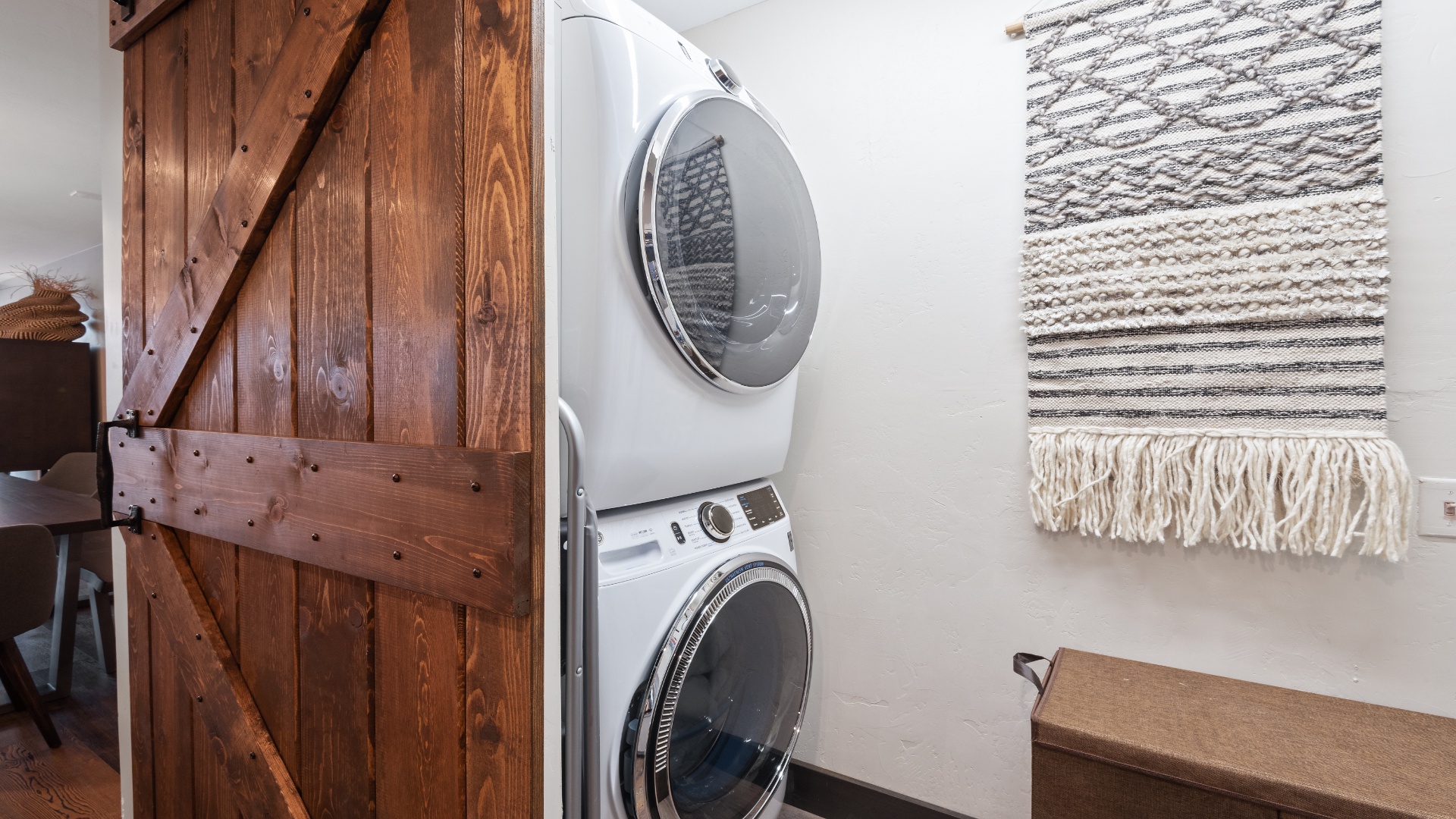 You'll find a convenient washer and dryer tucked into this charming nook, with rustic barn door details and cozy woven decor adding a homey touch to your stay.