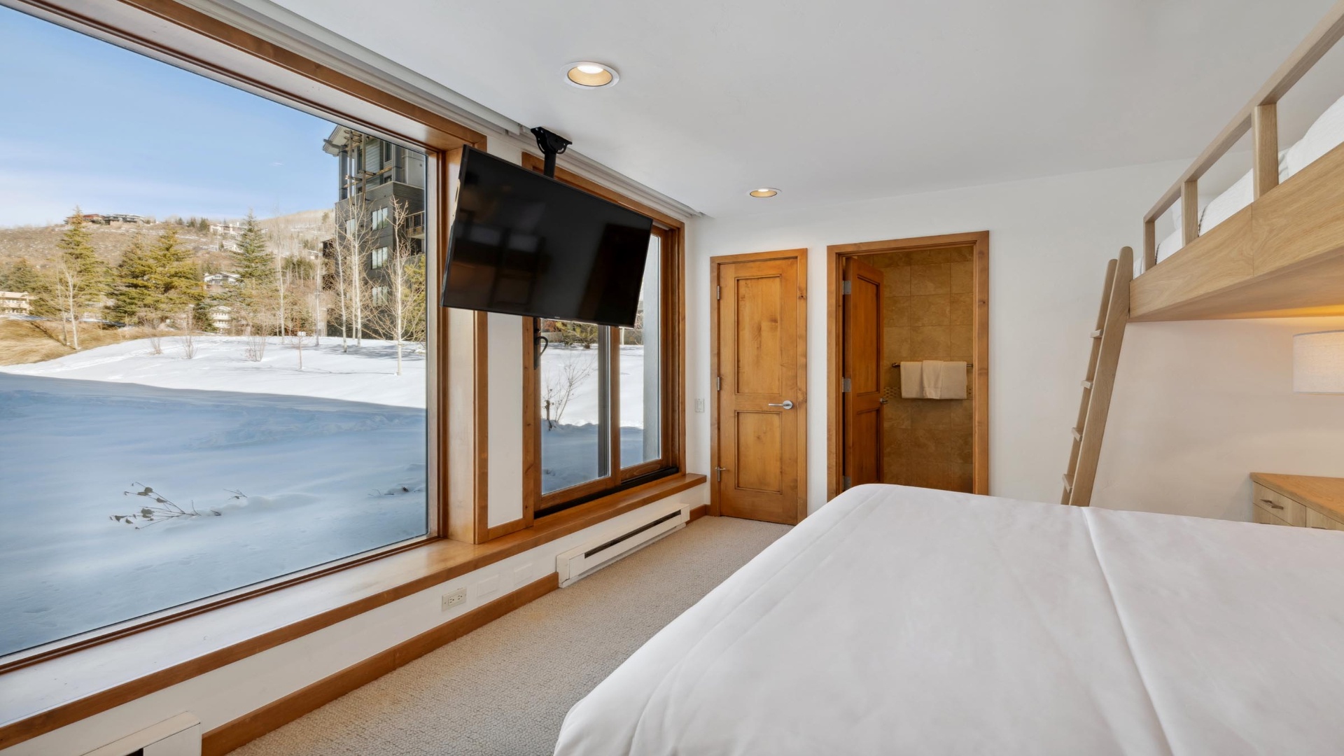 Wake up to stunning winter mountain views from your cozy bedroom, where fresh powder and peaceful landscapes await just outside your window.