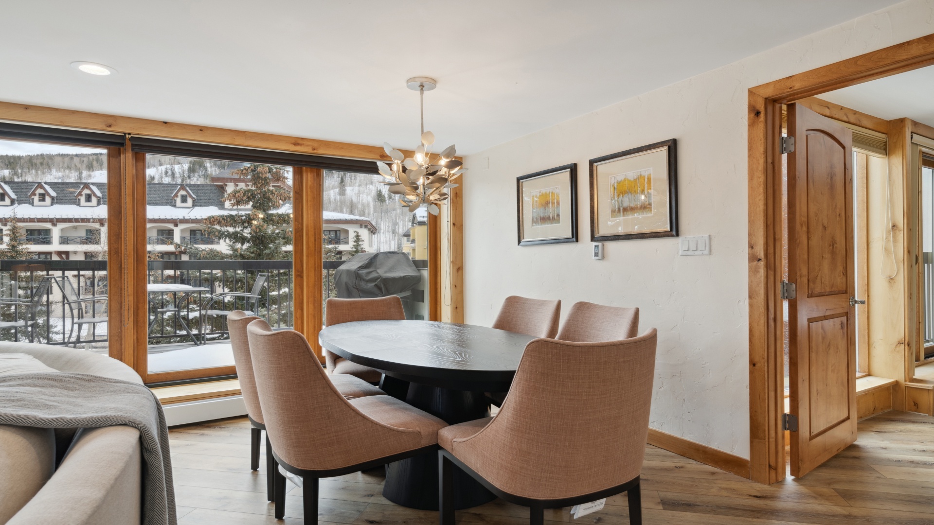 Gather around this elegant dining space where winter mountain views frame every meal. Rich wood accents and modern comfort create your ideal retreat for memorable moments together.