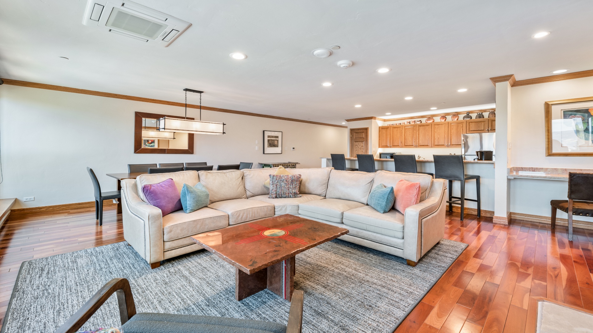 Unwind on plush sofas surrounded by warm hardwood floors and vibrant accents. Your open-concept living space flows seamlessly into the dining area and fully-equipped kitchen, perfect for gatherings and making memories.