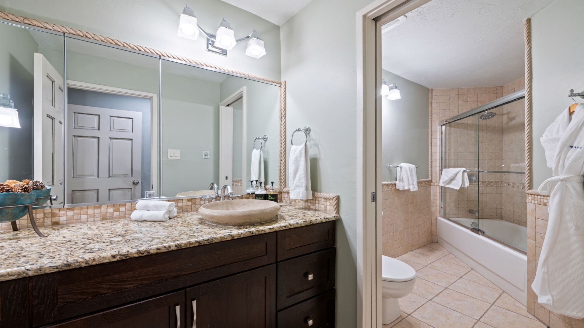 Step into your private sanctuary—a spacious bathroom with polished granite counters, soft towels, and a gleaming tub-shower combo inviting you to unwind after your day exploring.
