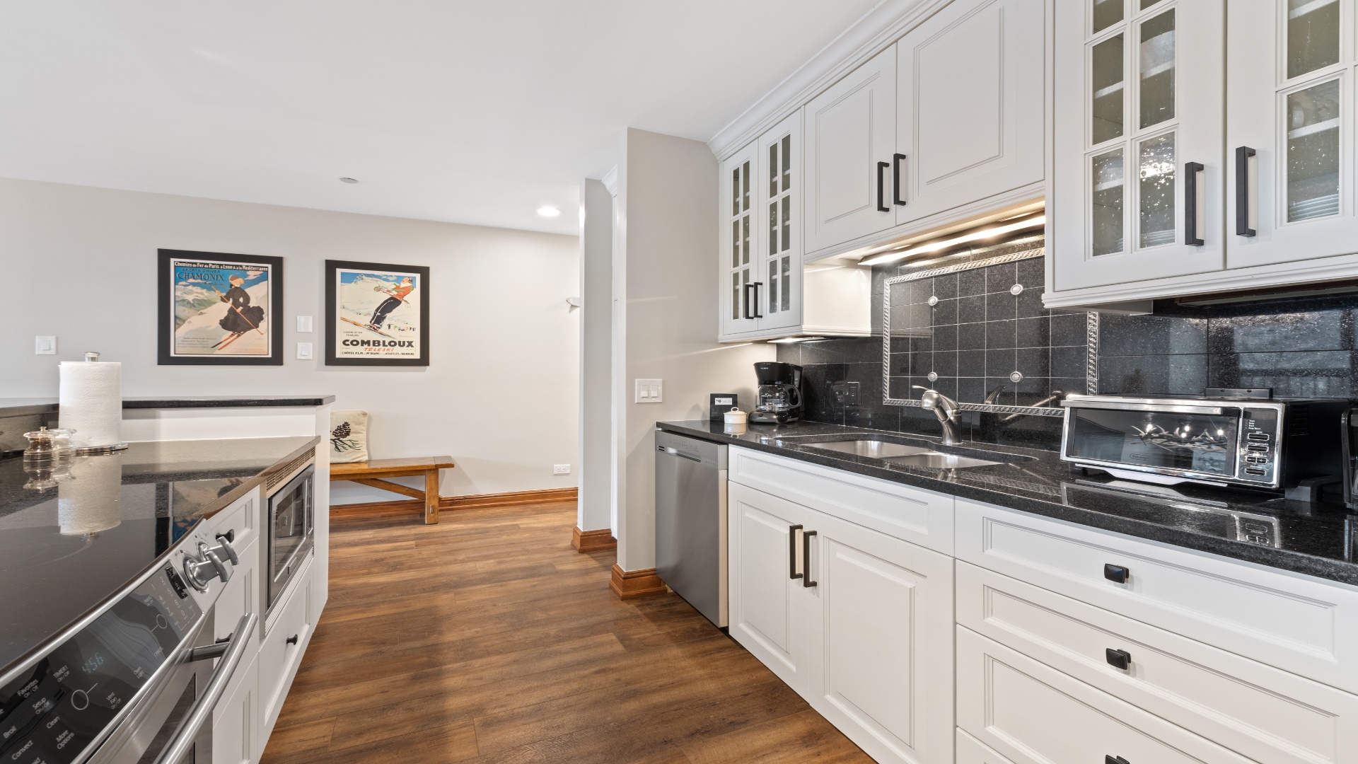 Picture yourself preparing meals in this fully equipped kitchen, featuring sleek white cabinetry, granite countertops, and stainless steel appliances—your home base for unforgettable vacation moments.