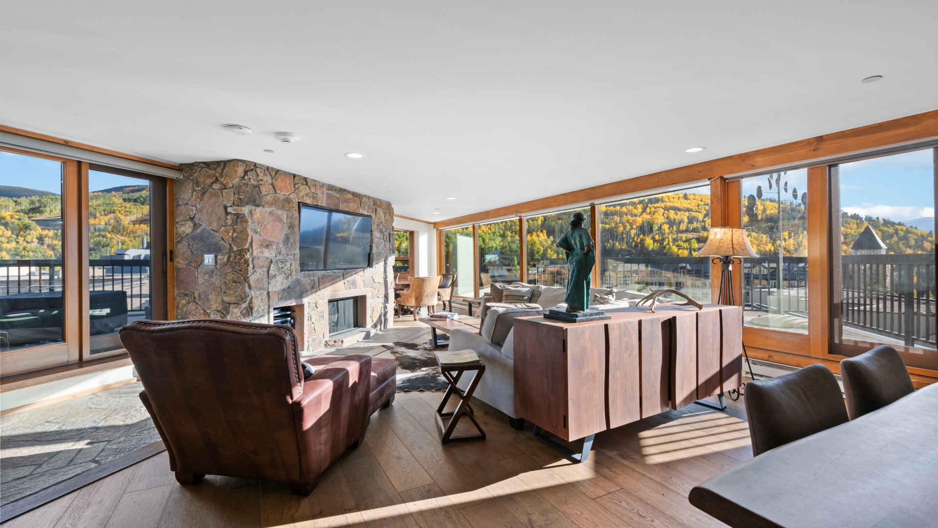 Sink into plush leather seating and soak in the stunning mountain vistas through floor-to-ceiling windows. The fireplace adds warmth while natural light fills your elegant retreat.