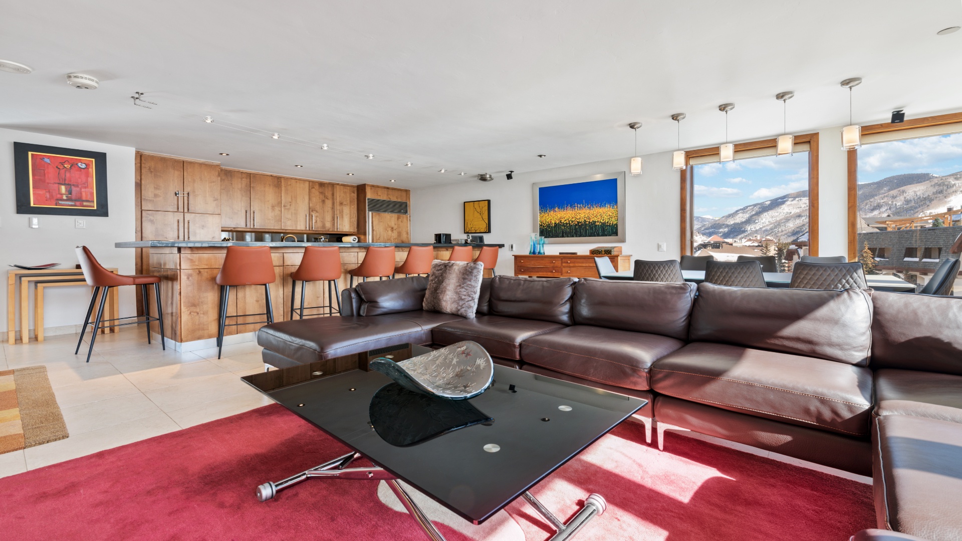 Sink into the plush leather sofa and gaze at stunning mountain views through floor-to-ceiling windows. Your spacious retreat blends modern style with cozy warmth for an unforgettable alpine getaway.