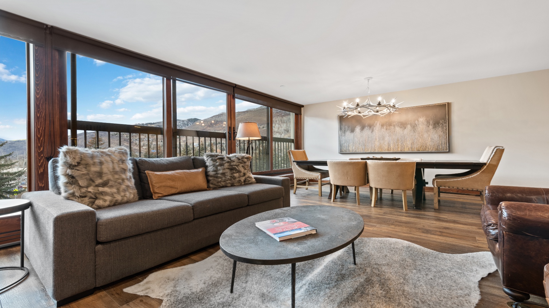 Relax in your spacious living and dining area, where floor-to-ceiling windows frame stunning mountain vistas. Sink into plush seating, enjoy meals together, and savor the natural light flooding this beautifully designed retreat.