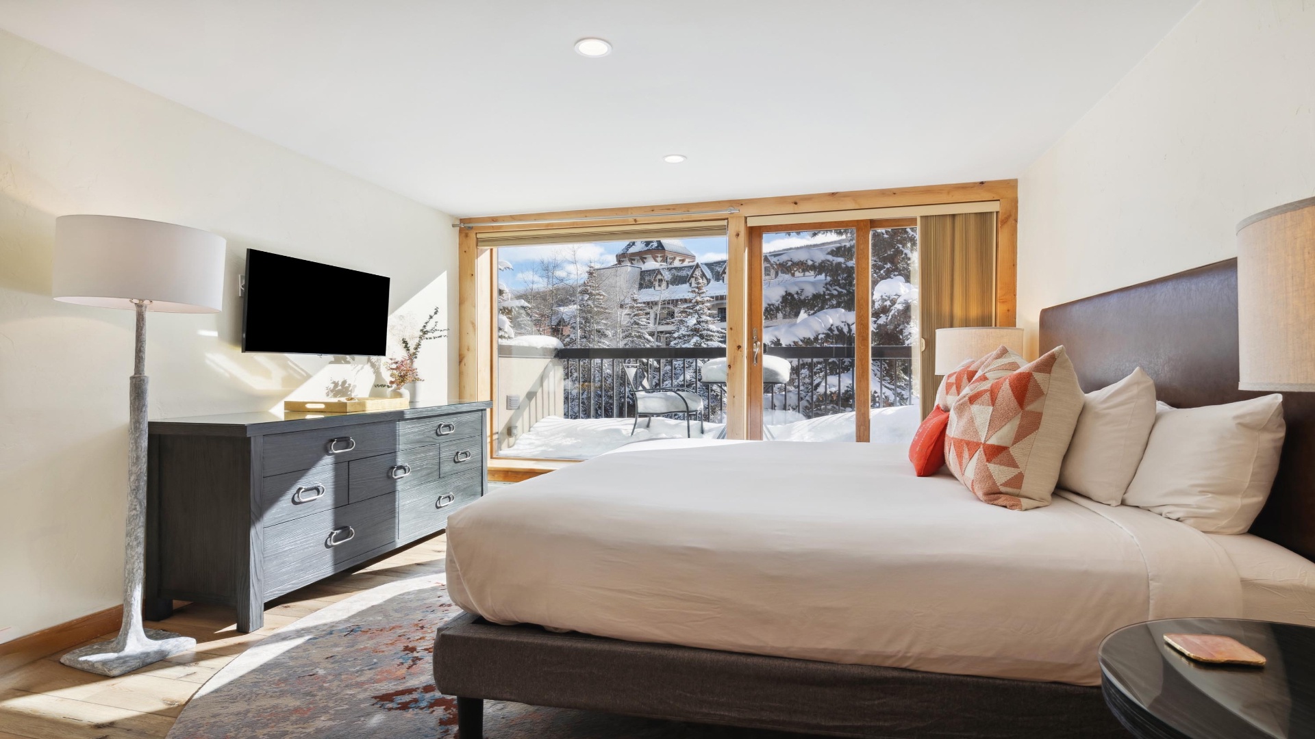 Imagine waking up to stunning snowy mountain vistas from your cozy bedroom, with sunlight streaming through large windows and modern comforts like a flat-screen TV welcoming you each morning.