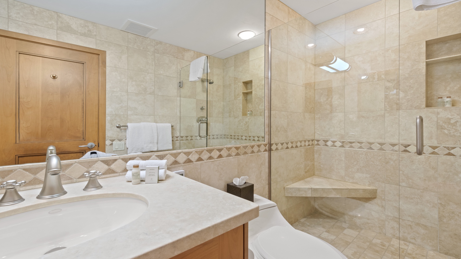 Step into your private sanctuary, where elegant tile work and a spacious walk-in shower invite you to unwind. Fresh towels and thoughtful touches ensure your every comfort.