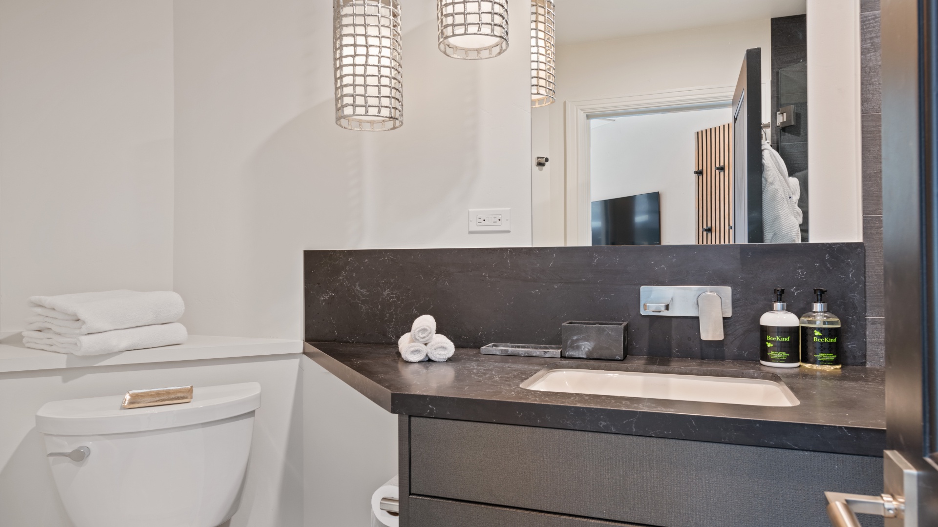 Your private bathroom features a sleek marble vanity with modern fixtures, fresh towels, and premium toiletries waiting for you. The space is bright, clean, and thoughtfully designed for your comfort.