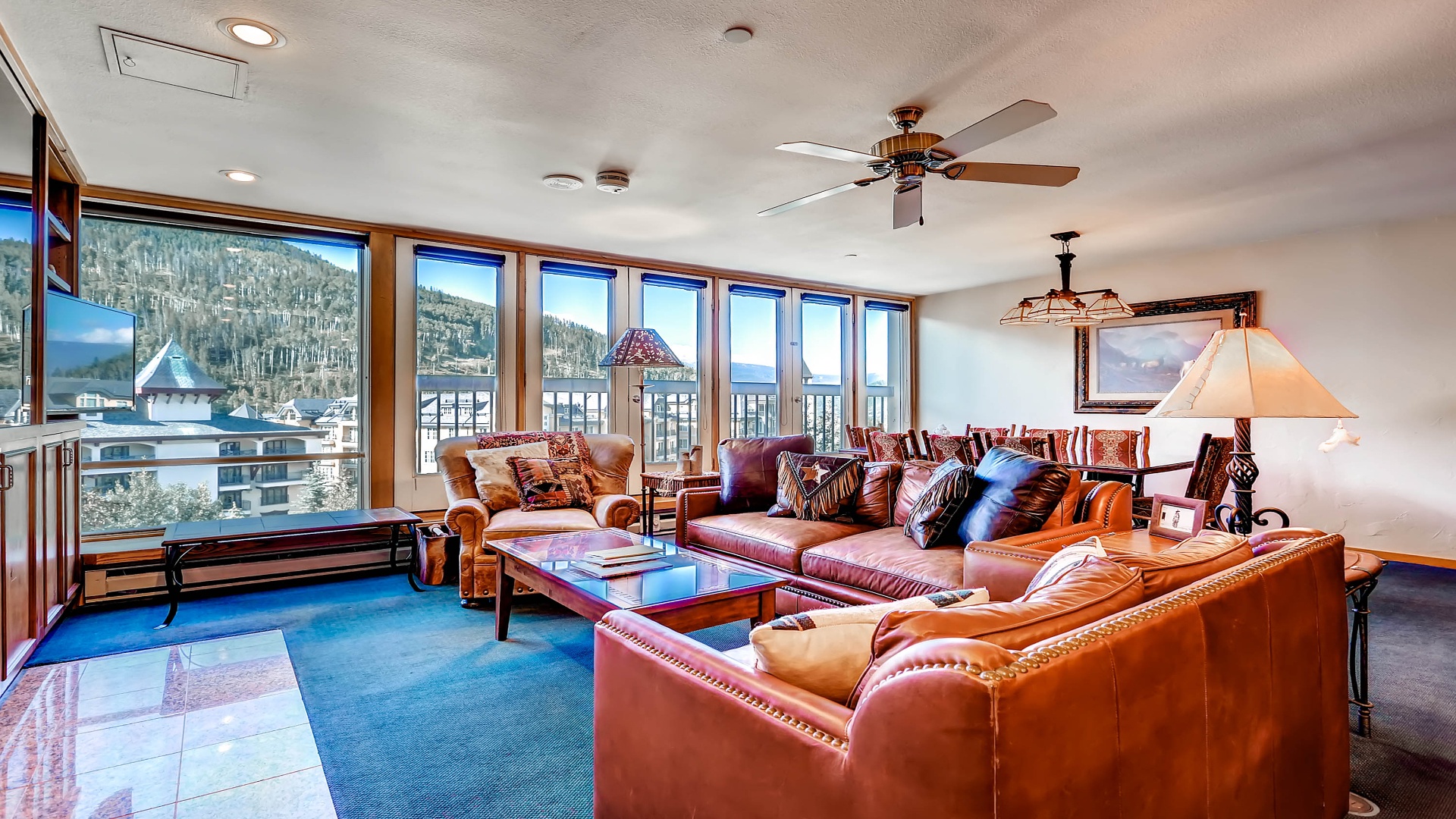 Settle into plush leather seating surrounded by mountain views through floor-to-ceiling windows. Natural light fills your living space, inviting relaxation after a day on the slopes.