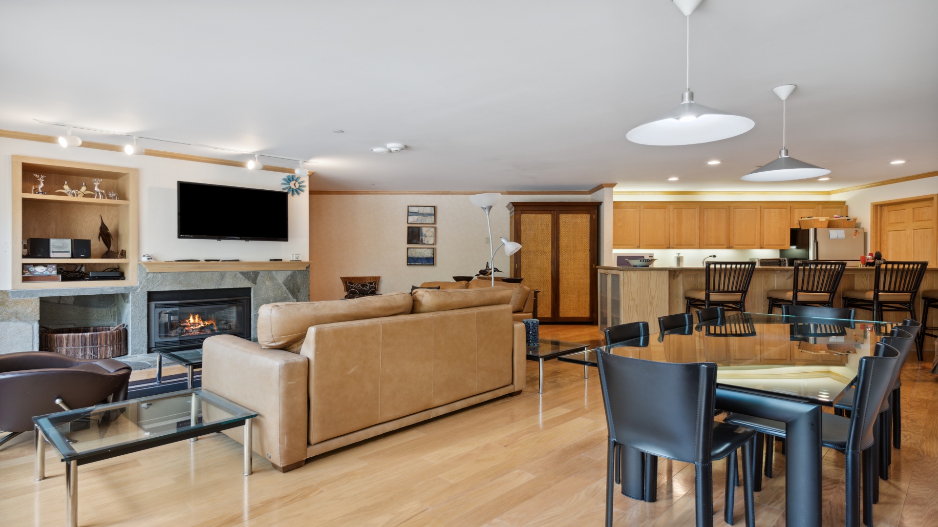 Your open-plan living and dining space seamlessly blends comfort and style with warm wood tones, a cozy fireplace, and modern kitchen—perfect for gathering with loved ones.