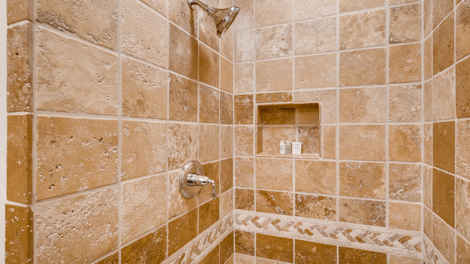 Step into your private tiled shower with dual fixtures and built-in niche—your refreshing retreat awaits after a day of adventure.