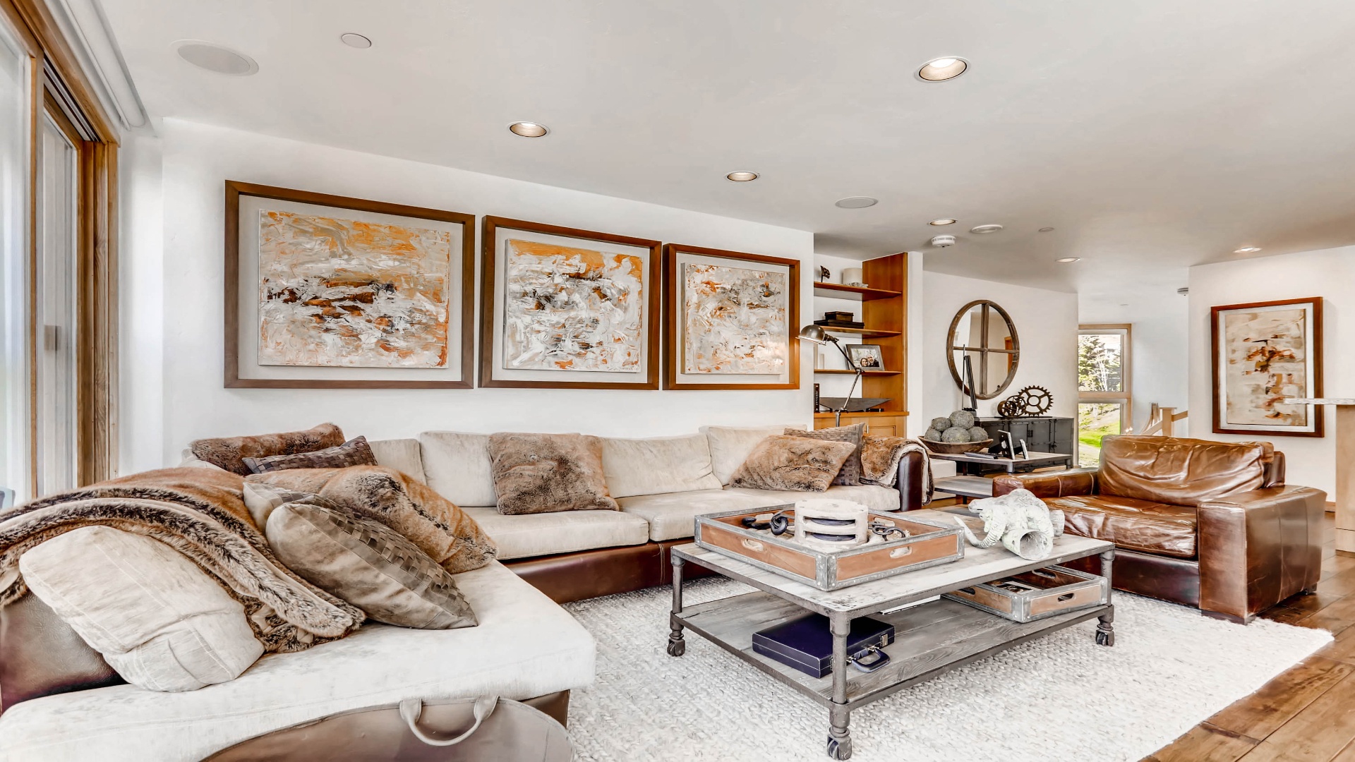 Sink into plush sofas in your spacious living room, where warm wood tones and curated artwork create an inviting retreat for relaxation and conversation.