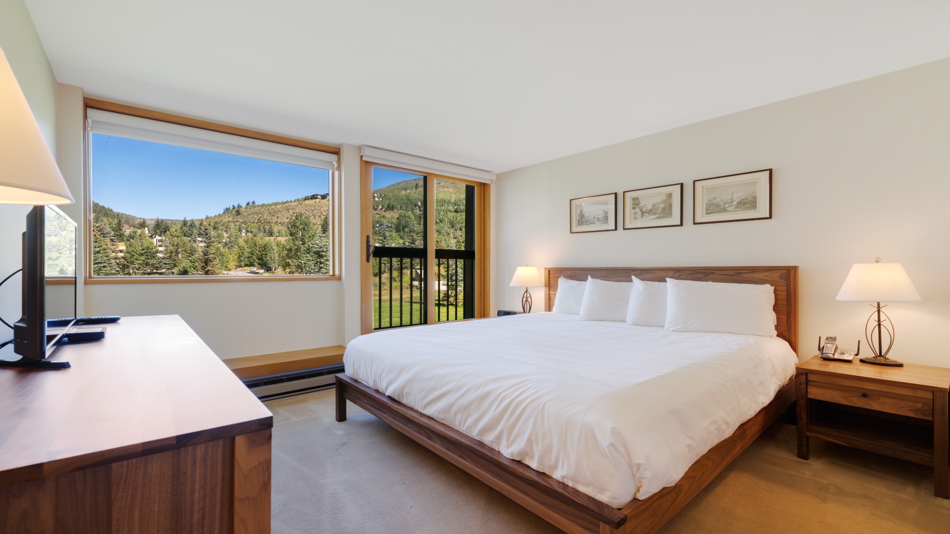 Wake up to stunning mountain views framed by large windows in this serene bedroom. Crisp white linens and warm wood tones create your perfect retreat after a day of adventure.