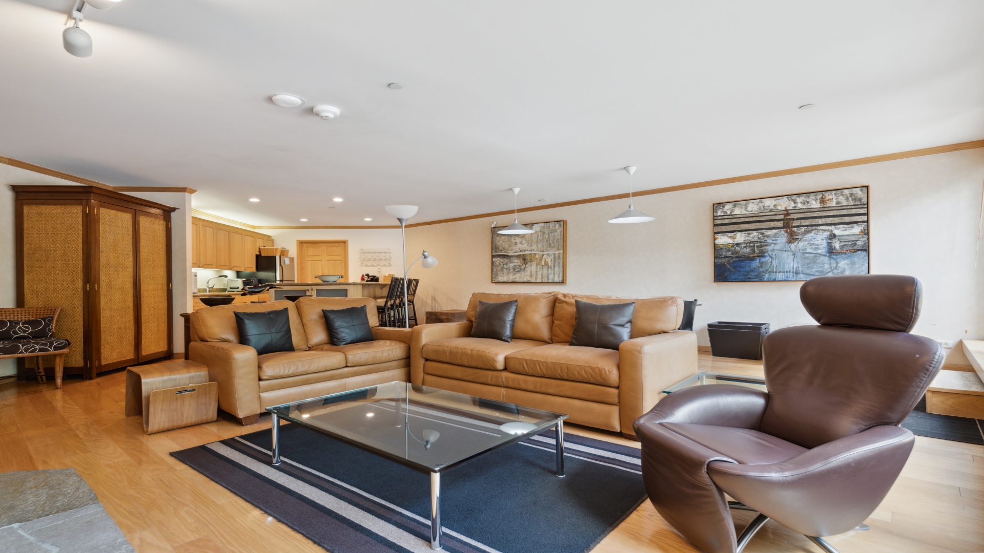 Unwind in your spacious living area with plush leather seating and modern comforts. The open floor plan flows into a well-equipped kitchen, creating a welcoming space for relaxing and entertaining.