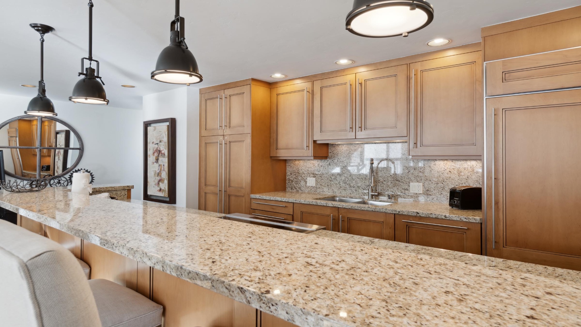 Your gourmet kitchen features elegant granite counters, warm wood cabinetry, and modern appliances—perfect for preparing memorable meals during your stay.