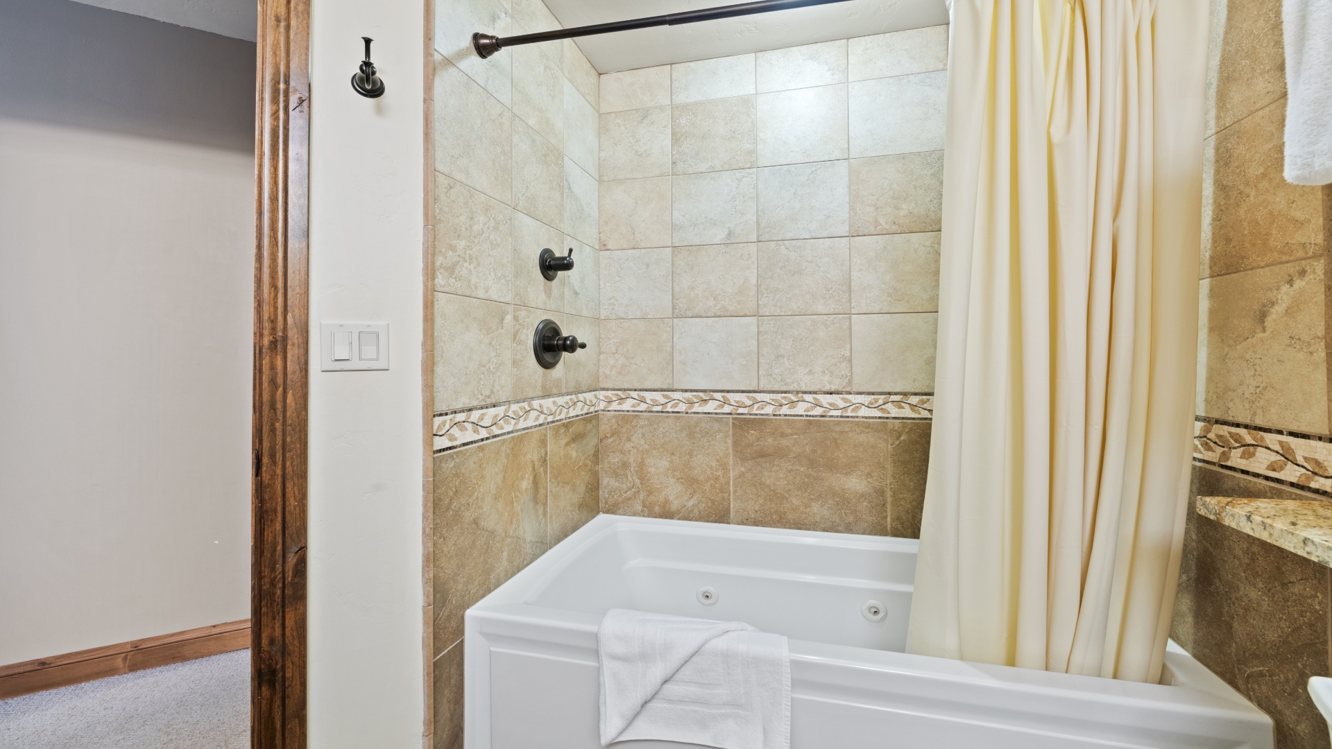 Slip into your private jetted tub after a long day exploring—soft tiles, warm tones, and a crisp towel waiting just for you.