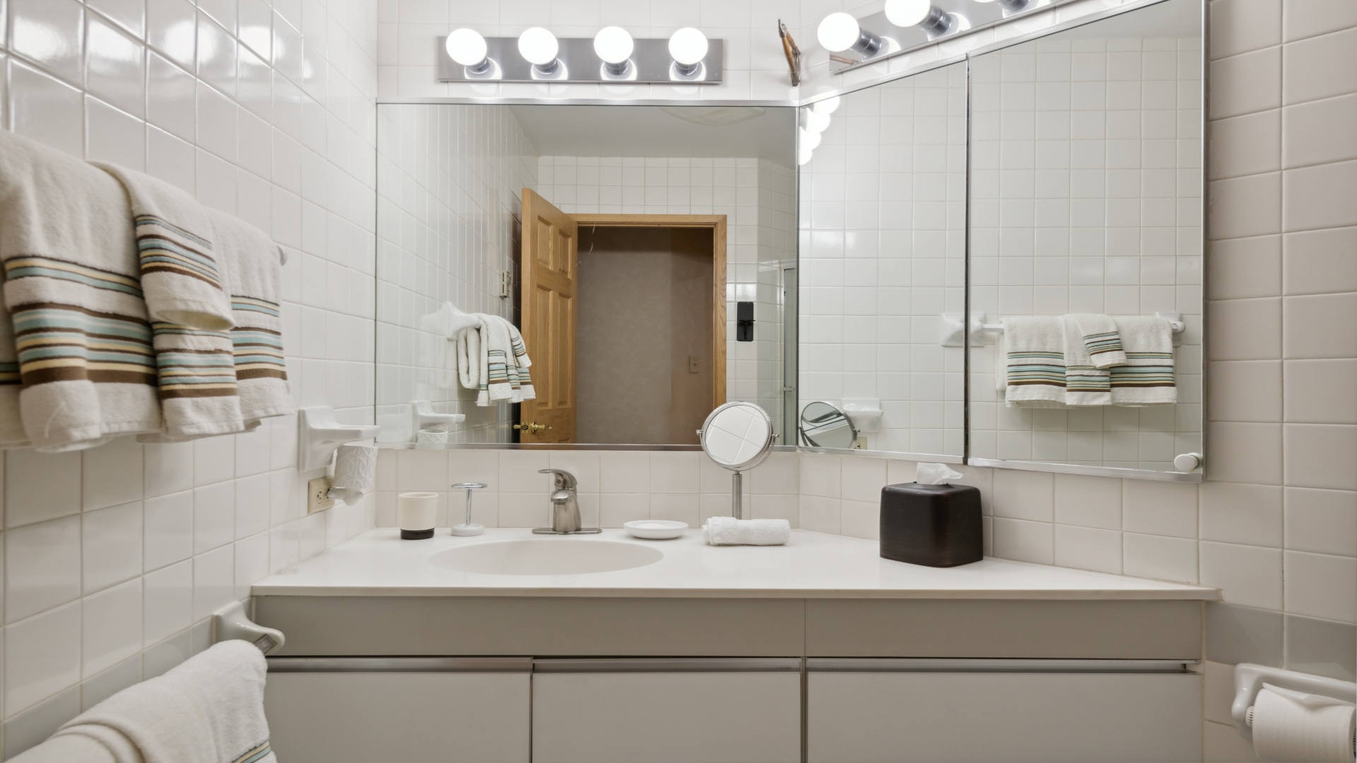 Step into your pristine private bathroom, where crisp white subway tiles, soft towels, and vanity lighting create a spa-like retreat for refreshing each morning.