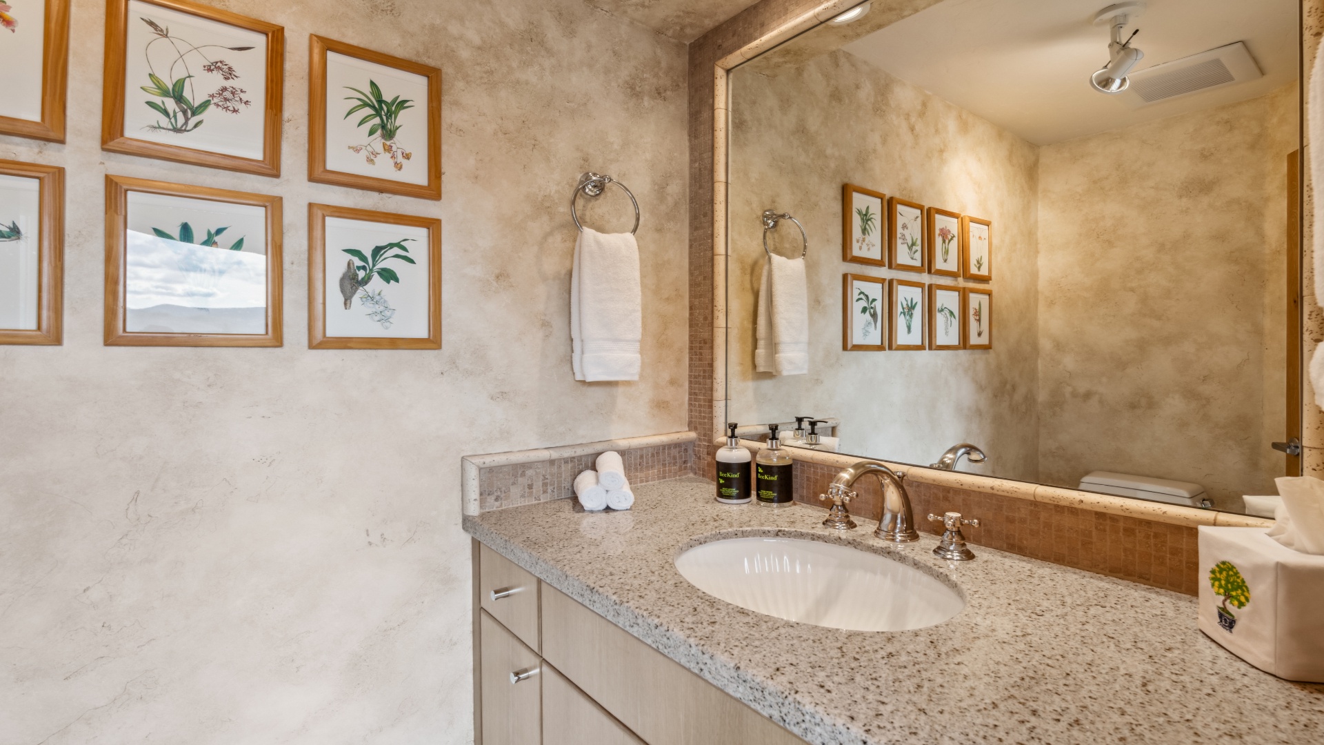 Step into your private bathroom, where botanical prints and granite countertops create a serene retreat. Fresh towels and luxury amenities await your arrival.