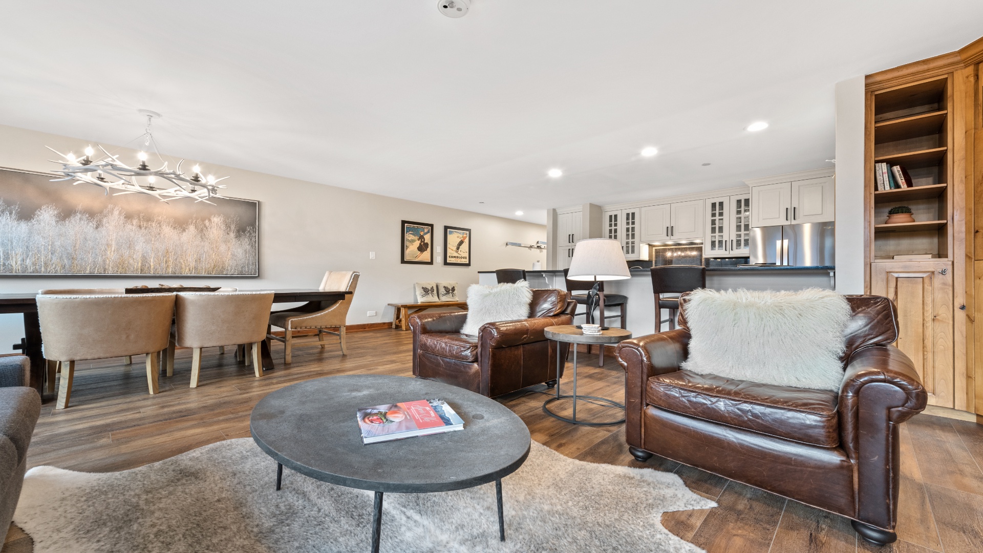 Unwind in your spacious open-concept living area, where leather seating, warm wood floors, and thoughtful design invite you to relax and feel at home.