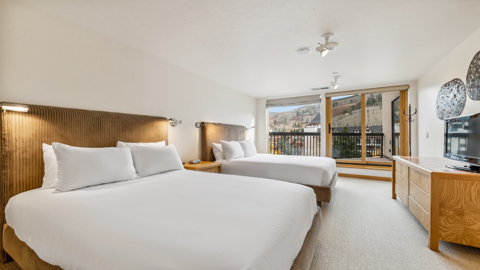 Two plush beds await you in this bright bedroom, where mountain views frame your mornings and cozy wood accents create a warm alpine retreat you'll never want to leave.