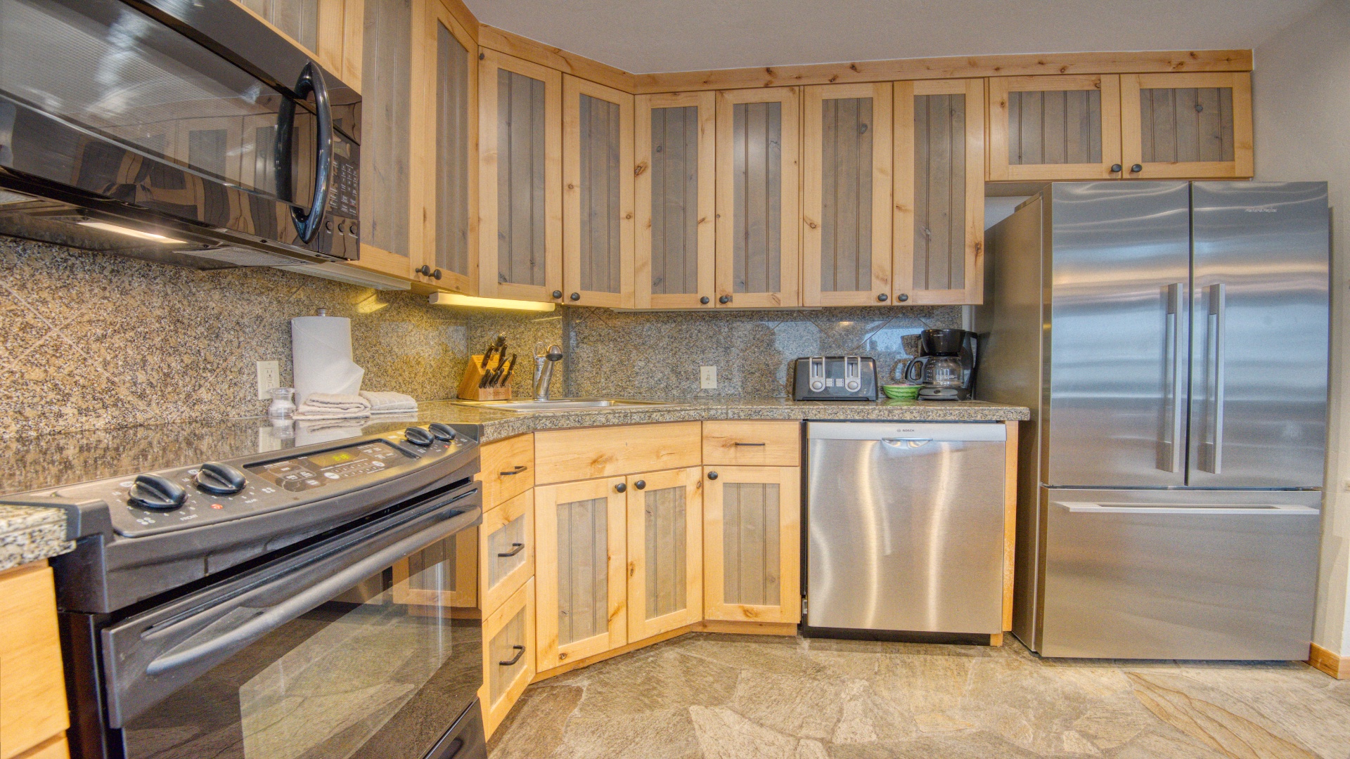 Your fully equipped kitchen features stainless steel appliances, granite countertops, and warm wood cabinetry—perfect for preparing meals and savoring your vacation mornings together.