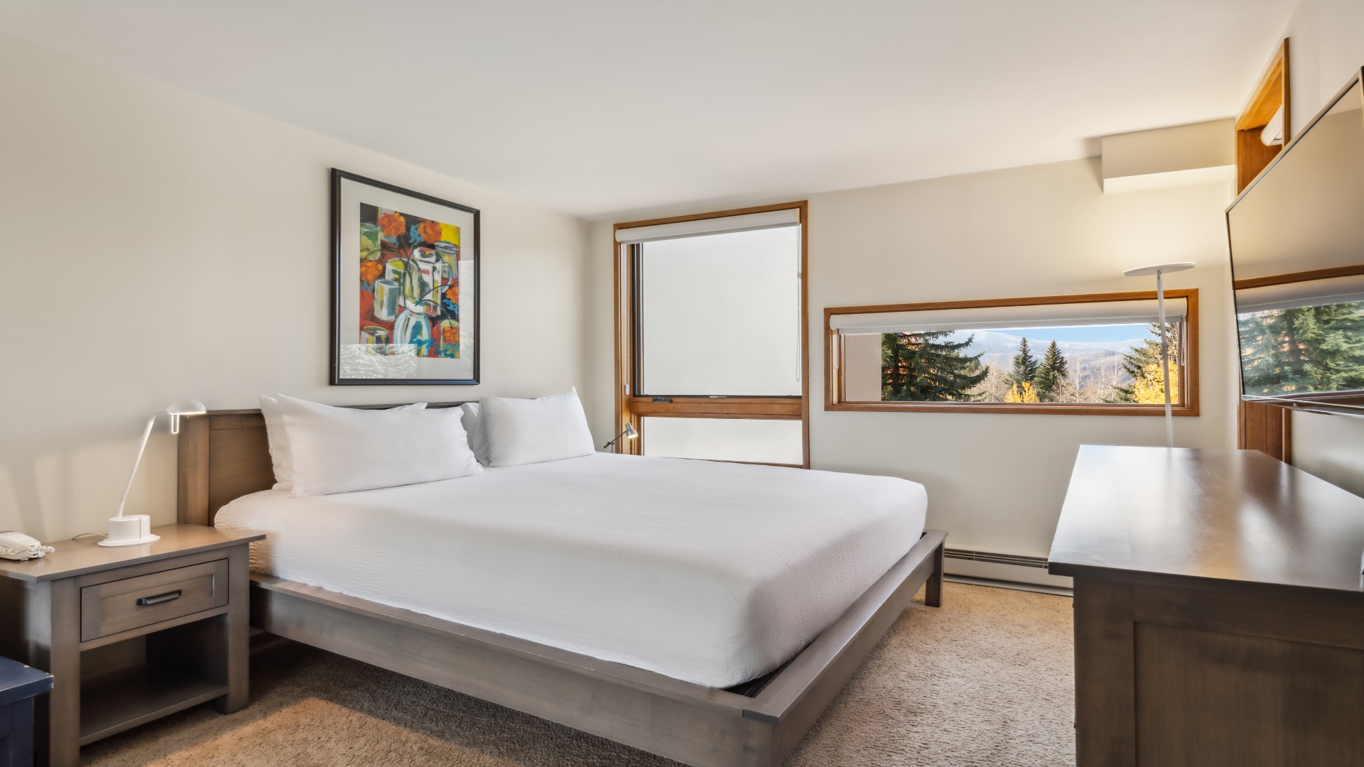 Wake to mountain vistas framed by thoughtfully placed windows. Crisp linens await your arrival on the king bed, while the workspace offers a spot for your morning coffee ritual.