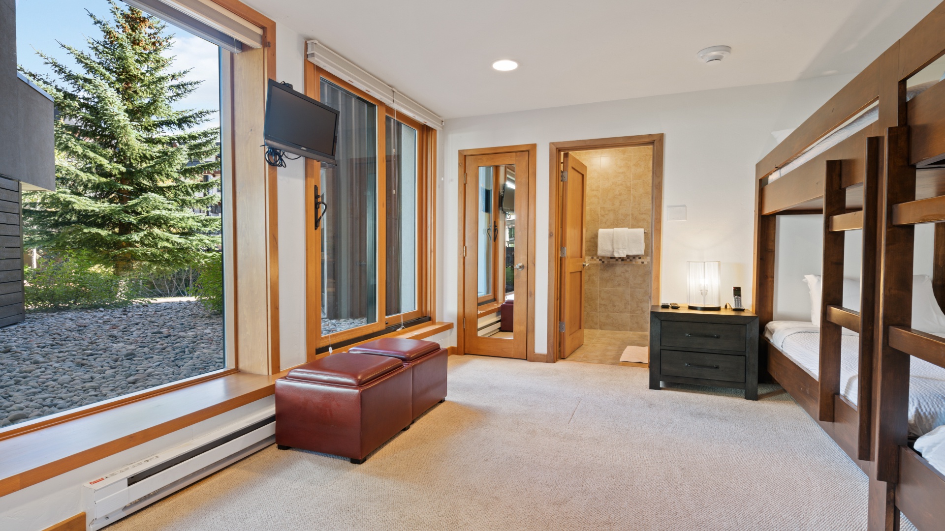 Settle into your restful retreat with warm wood accents, abundant natural light, and views of towering evergreens. Your cozy bedroom connects directly to the bathroom for ultimate convenience.