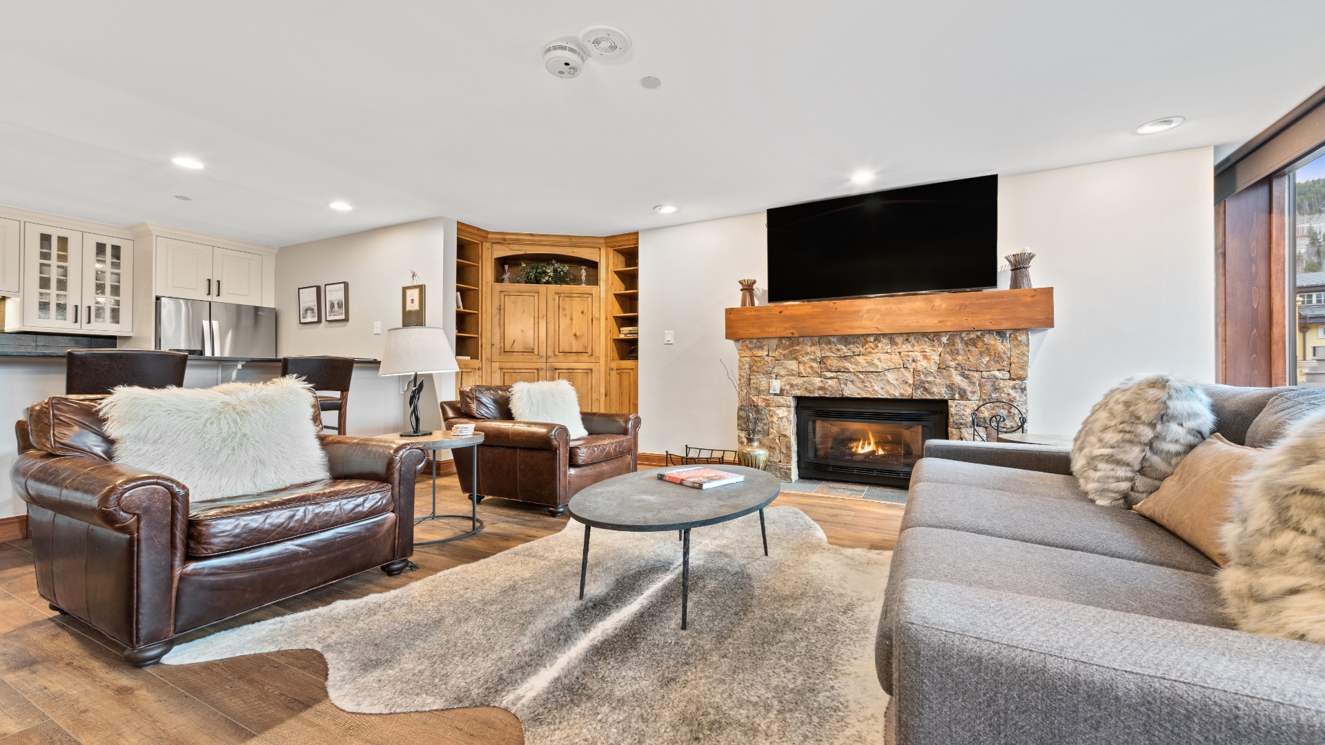 Sink into soft leather and plush cushions in your inviting living room, where a crackling stone fireplace sets the mood for cozy mountain evenings with loved ones.