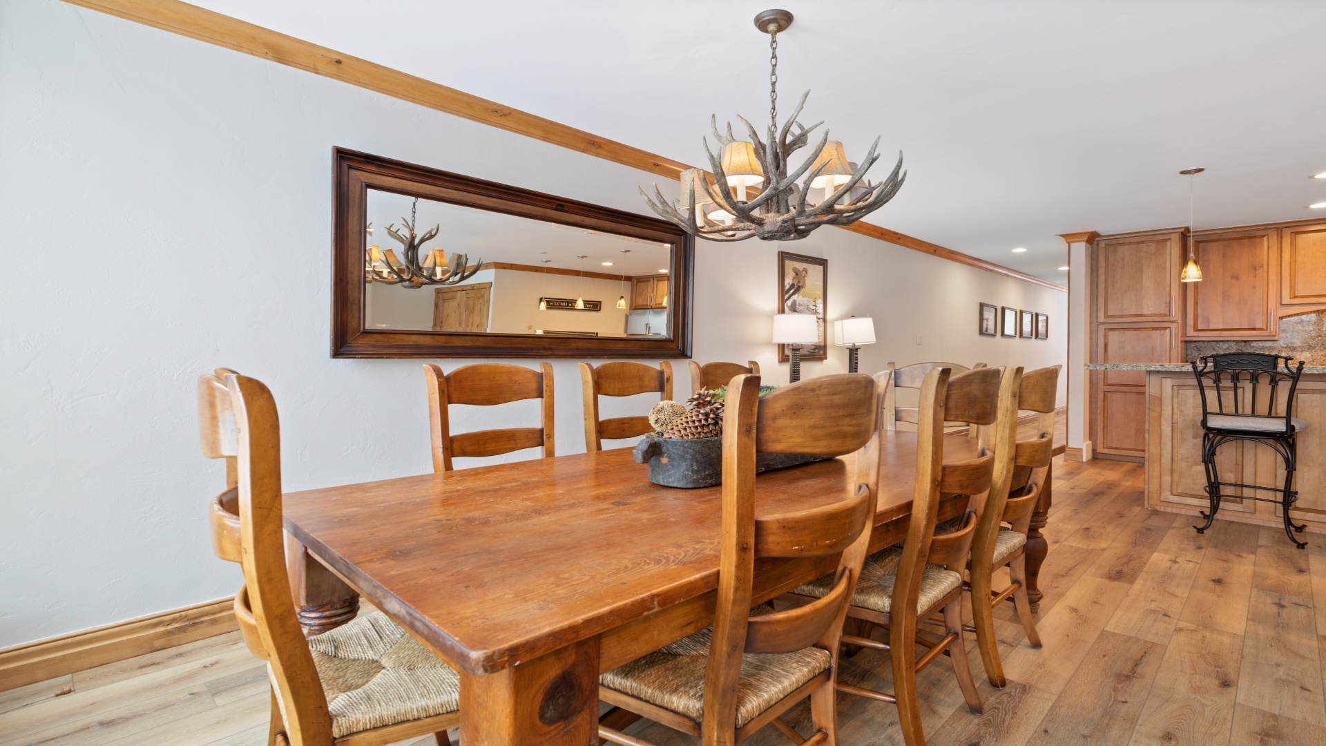 Gather around this spacious table for hearty meals and memorable conversations, lit by a striking antler chandelier that brings rustic elegance to your dining experience.