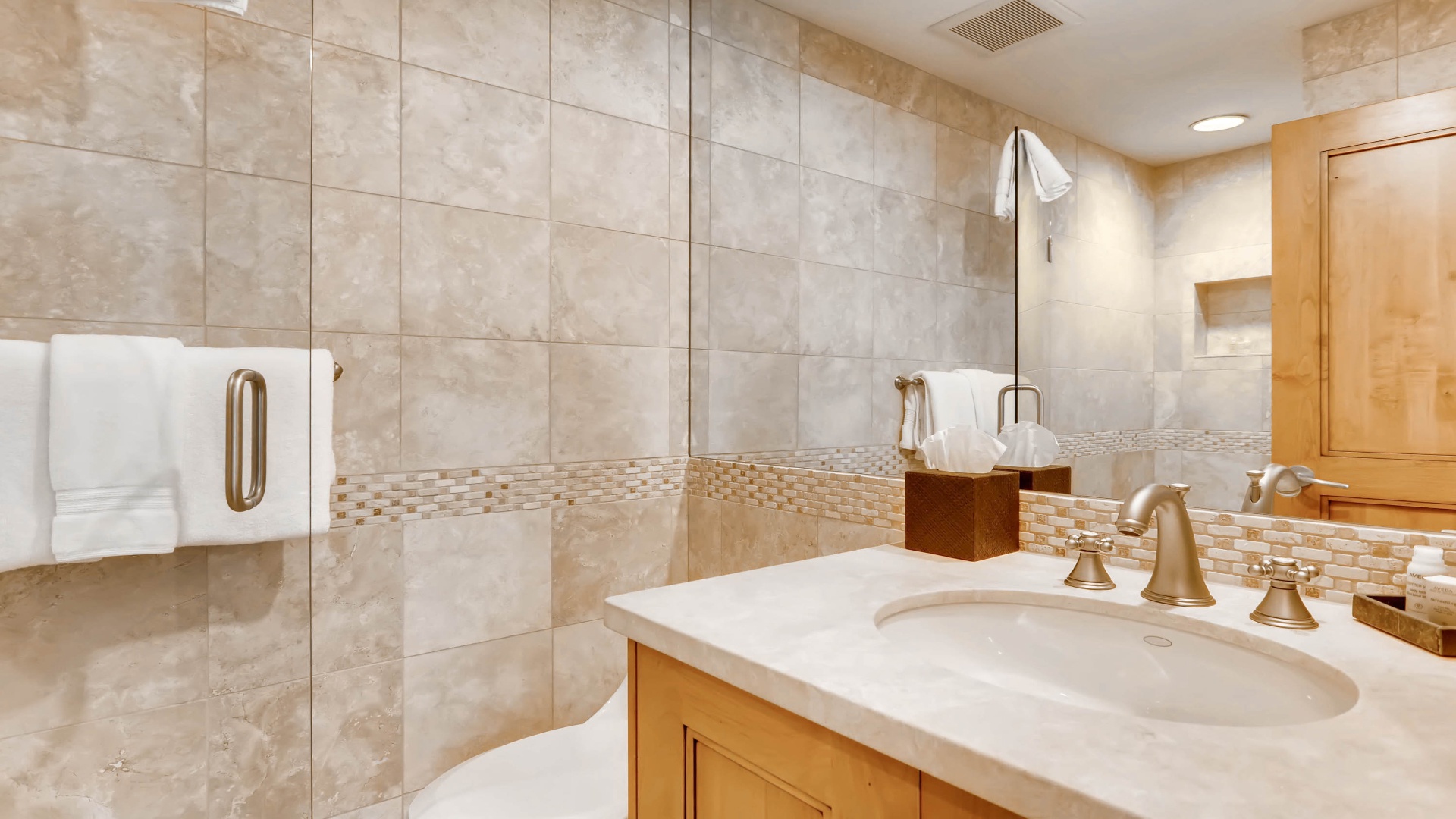 Your private bathroom features elegant tile work, pristine countertops, and plush towels ready for your arrival. Relax in this spa-like space designed for your comfort and convenience.