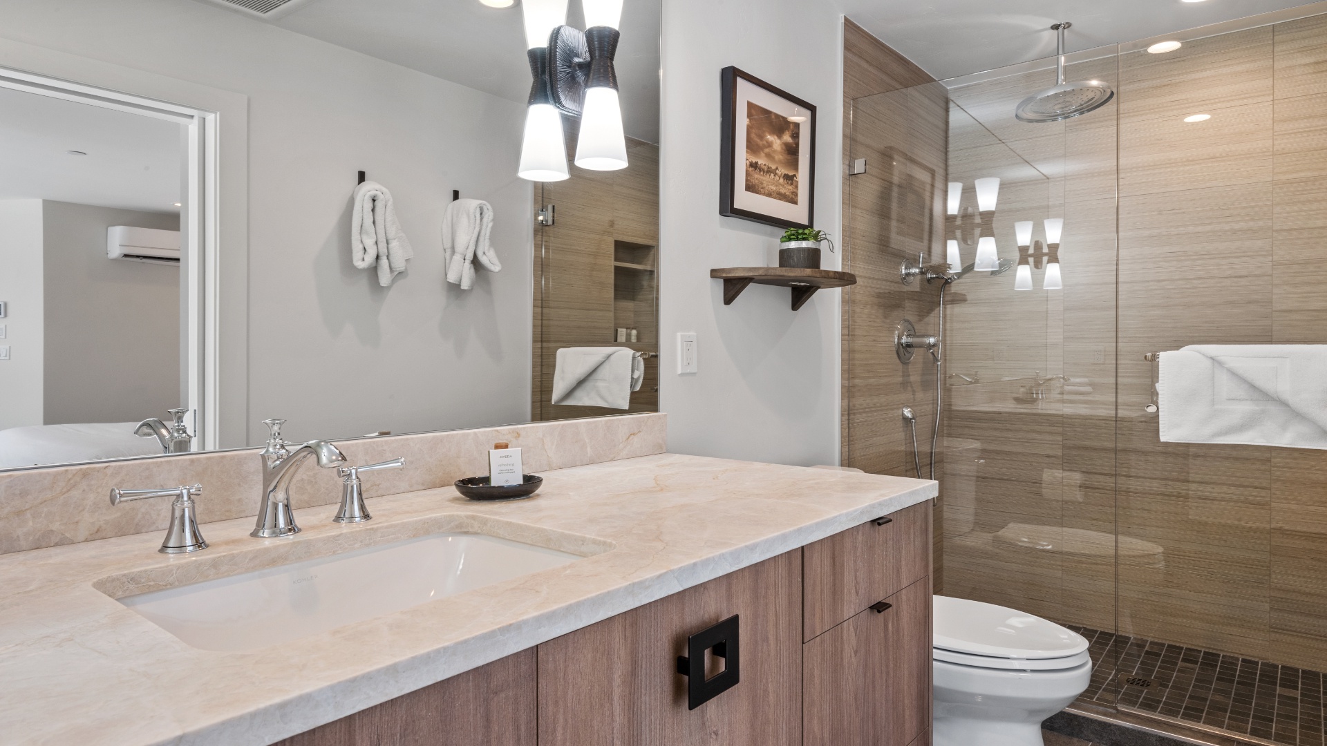 Step into your serene spa-like bathroom with warm wood tones, plush robes awaiting you, and a rainfall shower that invites relaxation after your adventures.
