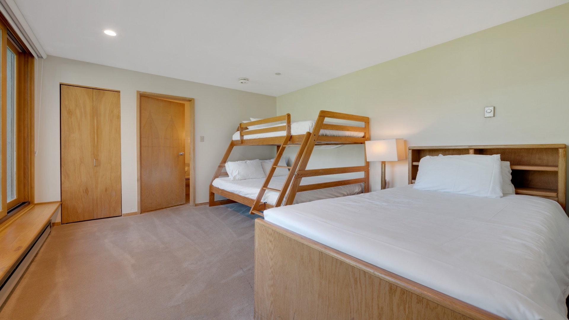 Your spacious bedroom features a comfortable double bed and sturdy bunk beds, perfect for families or groups seeking a restful night together in a bright, welcoming space.